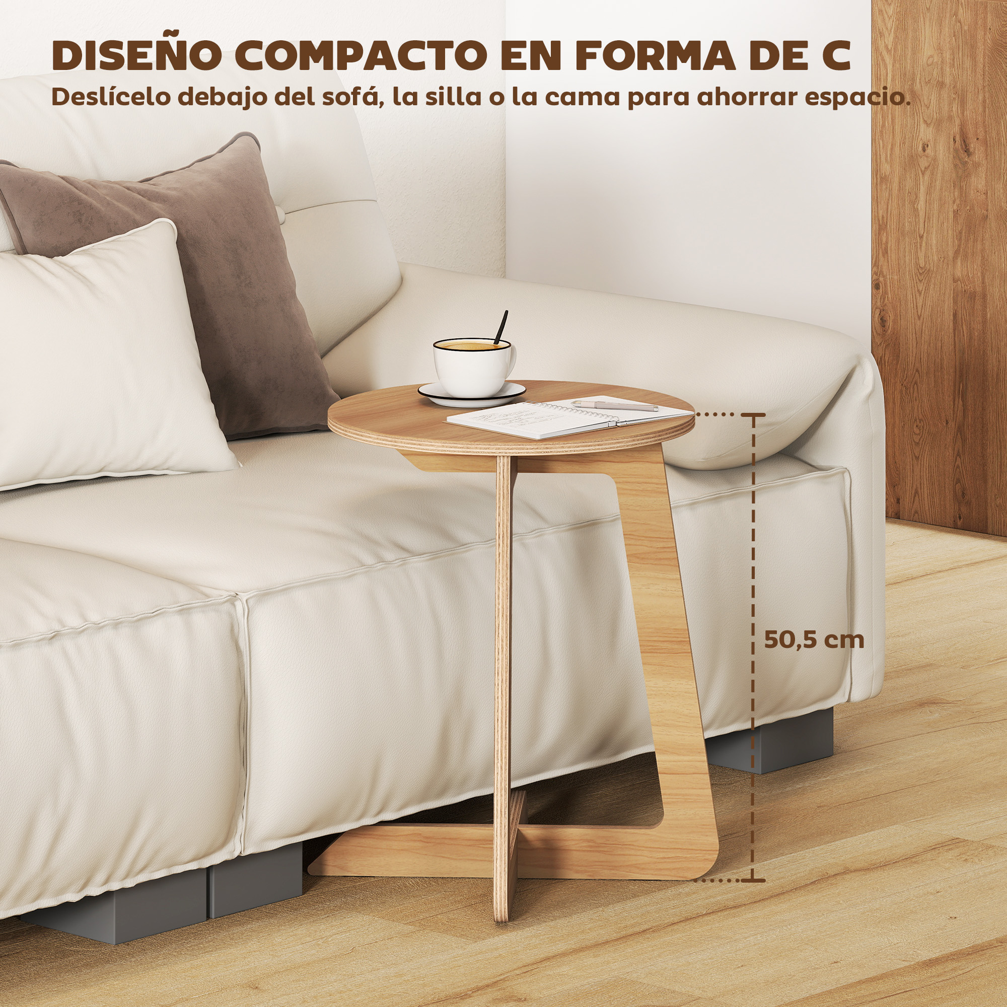 Una mesa auxiliar en forma de C junto a un sofá blanco con taza y libreta.