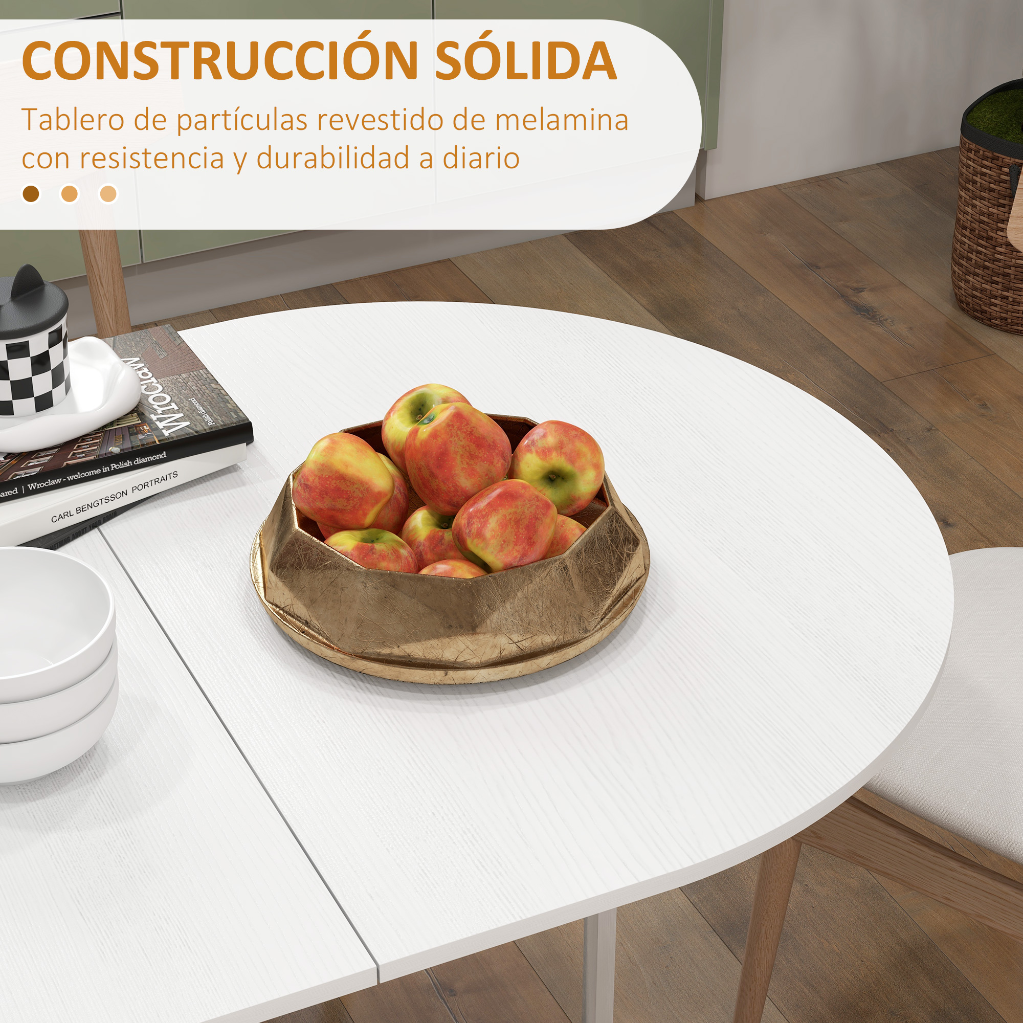 Una mesa blanca con manzanas en un cuenco dorado, libros y cuencos.