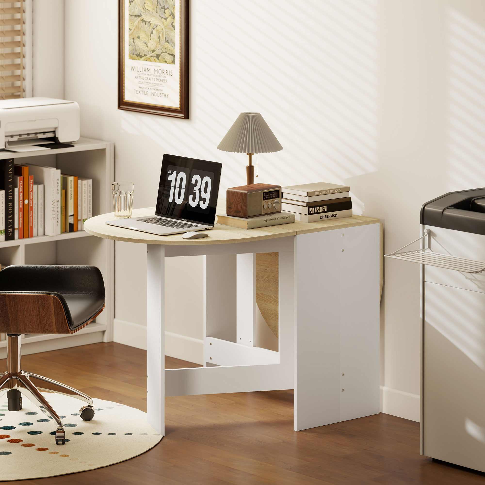 Un escritorio con portátil, lámpara, radio y libros. Una silla delante.