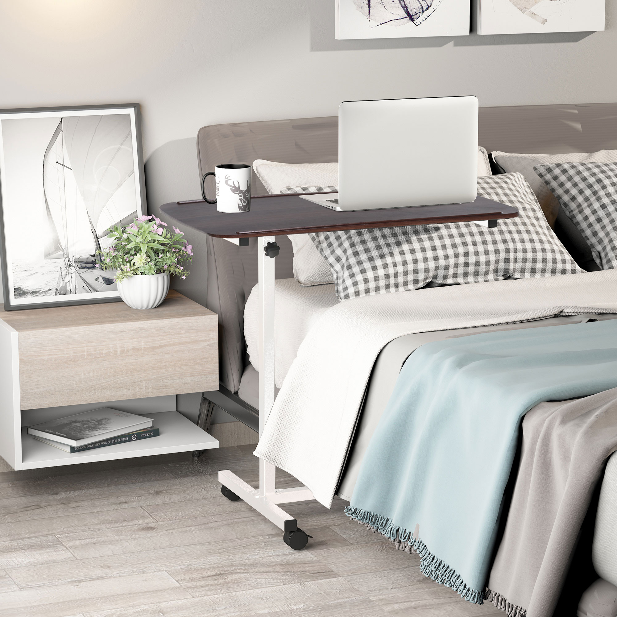 Una mesa de noche ajustable con un portátil sobre la cama.