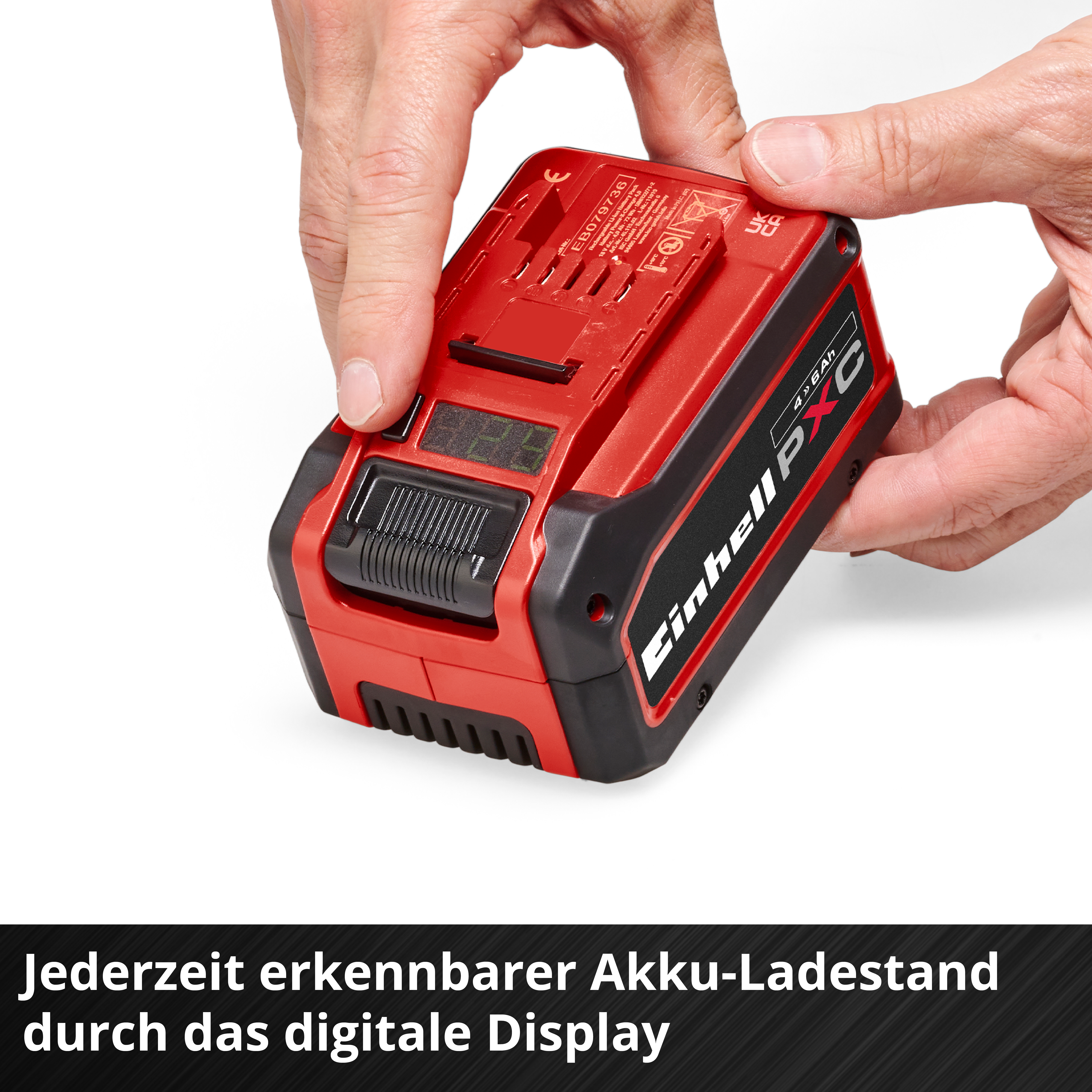 Rote Batterie mit digitaler Anzeige wird von Händen gehalten.
