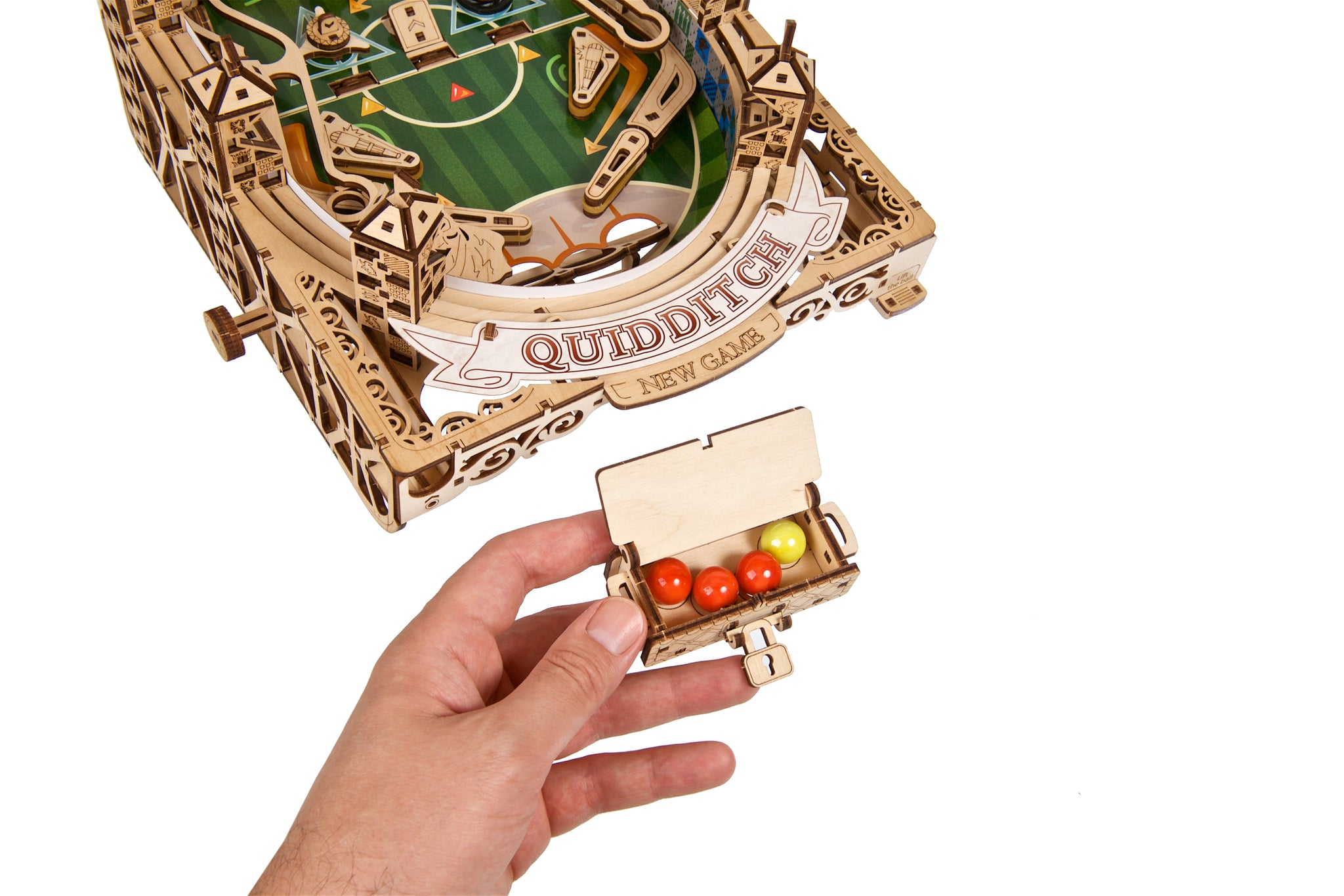 Ein hölzerner Quidditch-Flipperautomat mit einem von einer Hand gehaltenen Kasten mit Bällen.