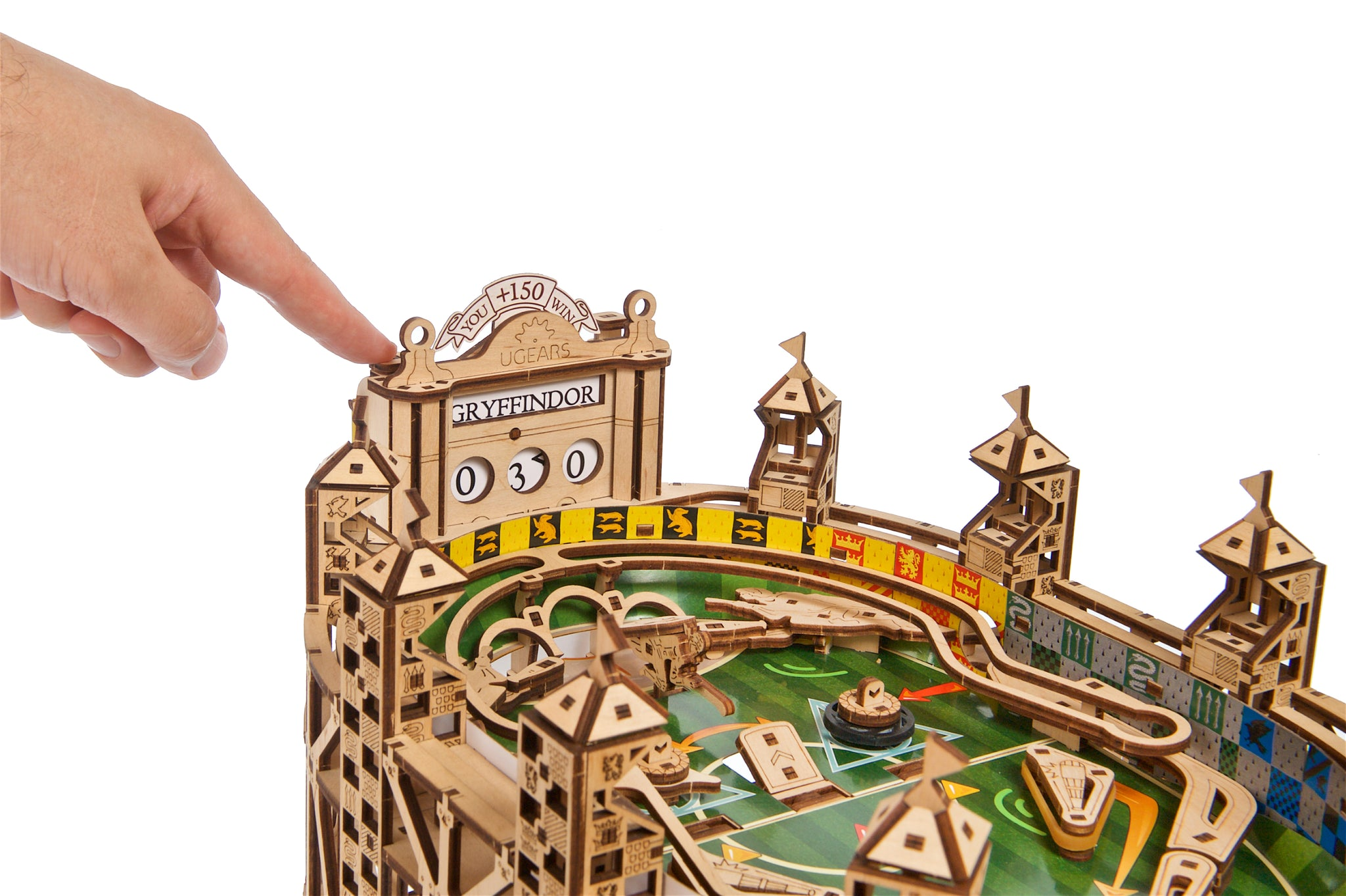 Ein Finger tippt auf ein Holz-Pinballspiel mit dem Namen GRYFFINDOR und der Punktzahl 030.