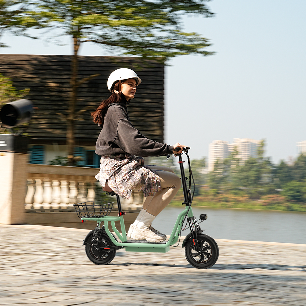 Una donna guida uno scooter elettrico verde menta con casco su un sentiero lungomare.