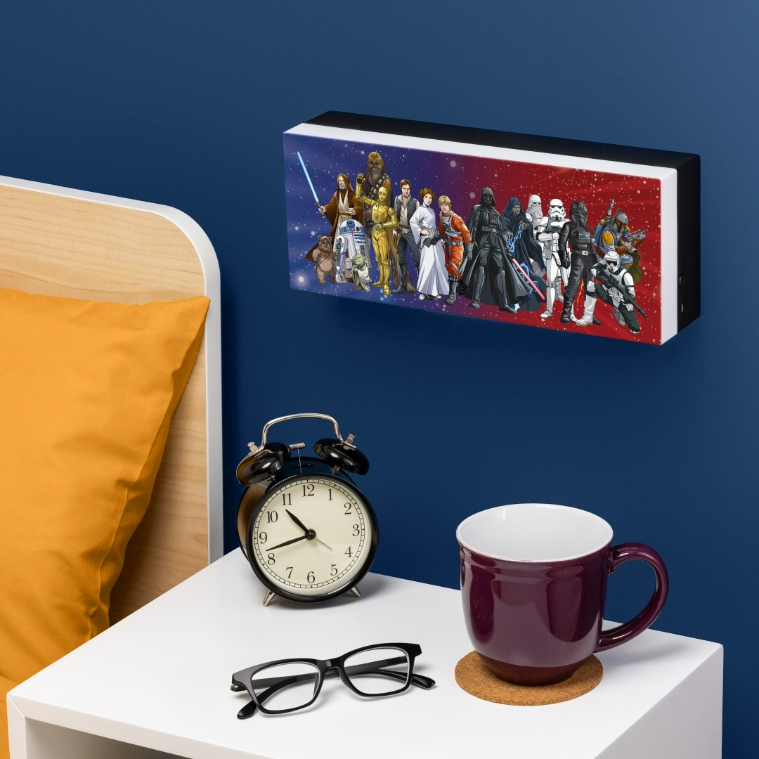 Postacie Star Wars na dekoracji ściennej nad stolikiem nocnym z budzikiem.