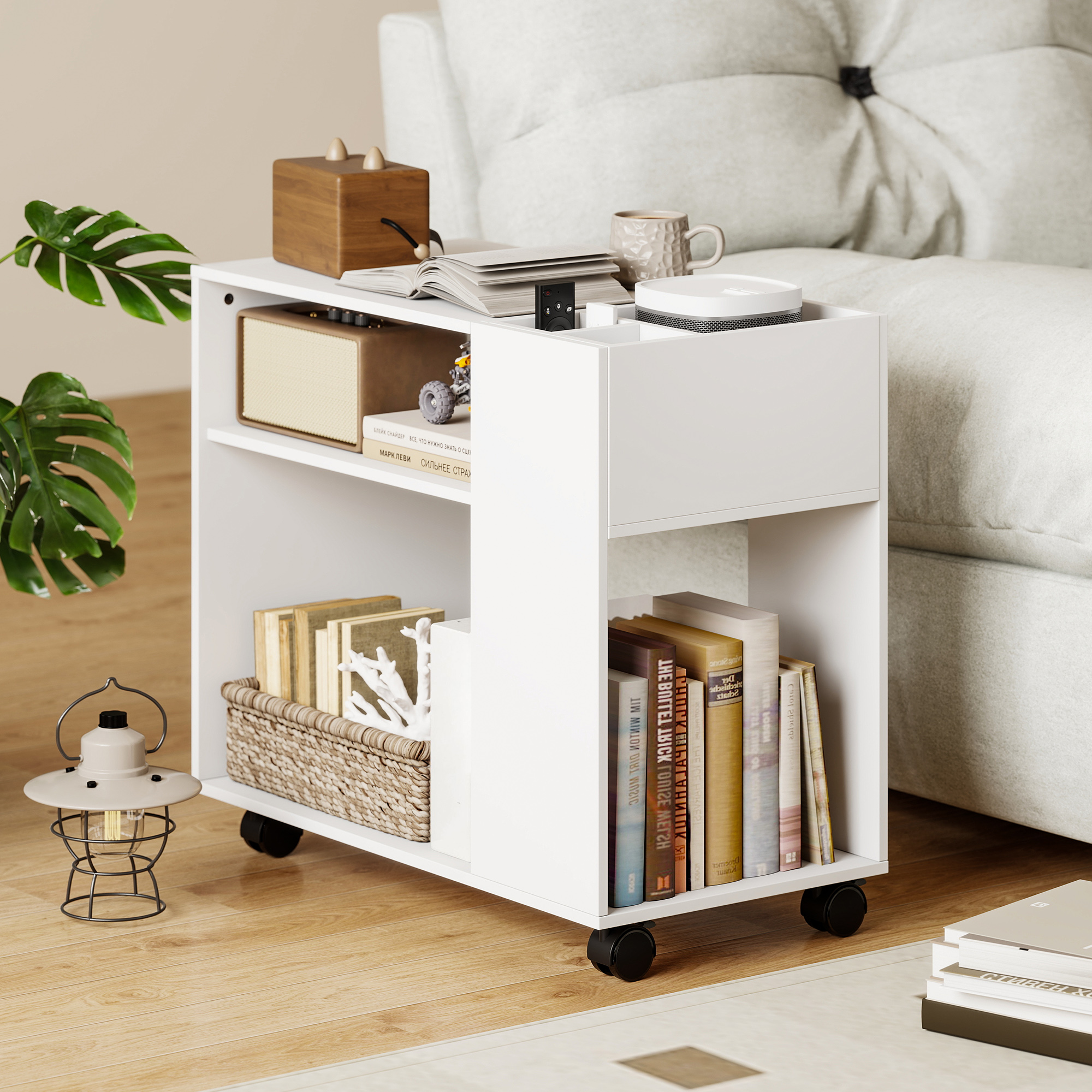 Una mesita auxiliar blanca con libros, lámpara y objetos decorativos.