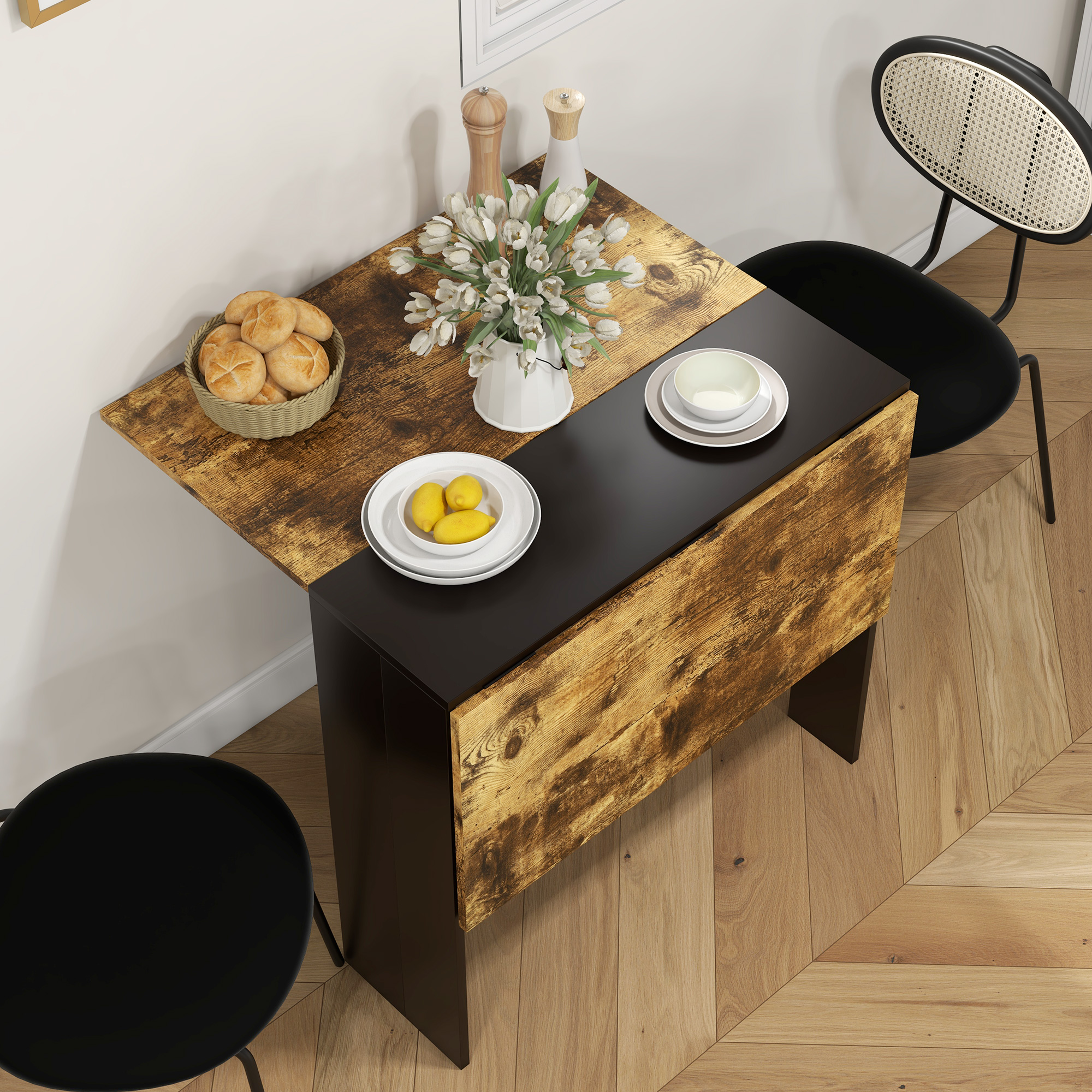 Una mesa abatible con veta de madera, tulipanes blancos, bollos y limones.