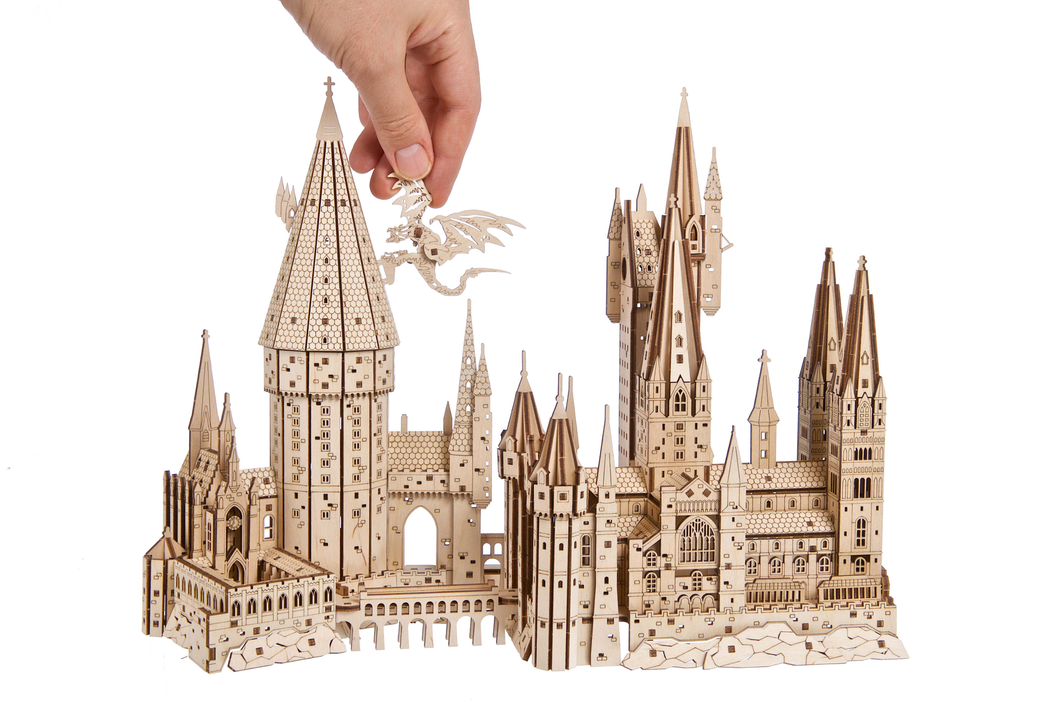Holzmodell von Schloss Hogwarts mit einer Hand, die ein Drachenteil platziert.