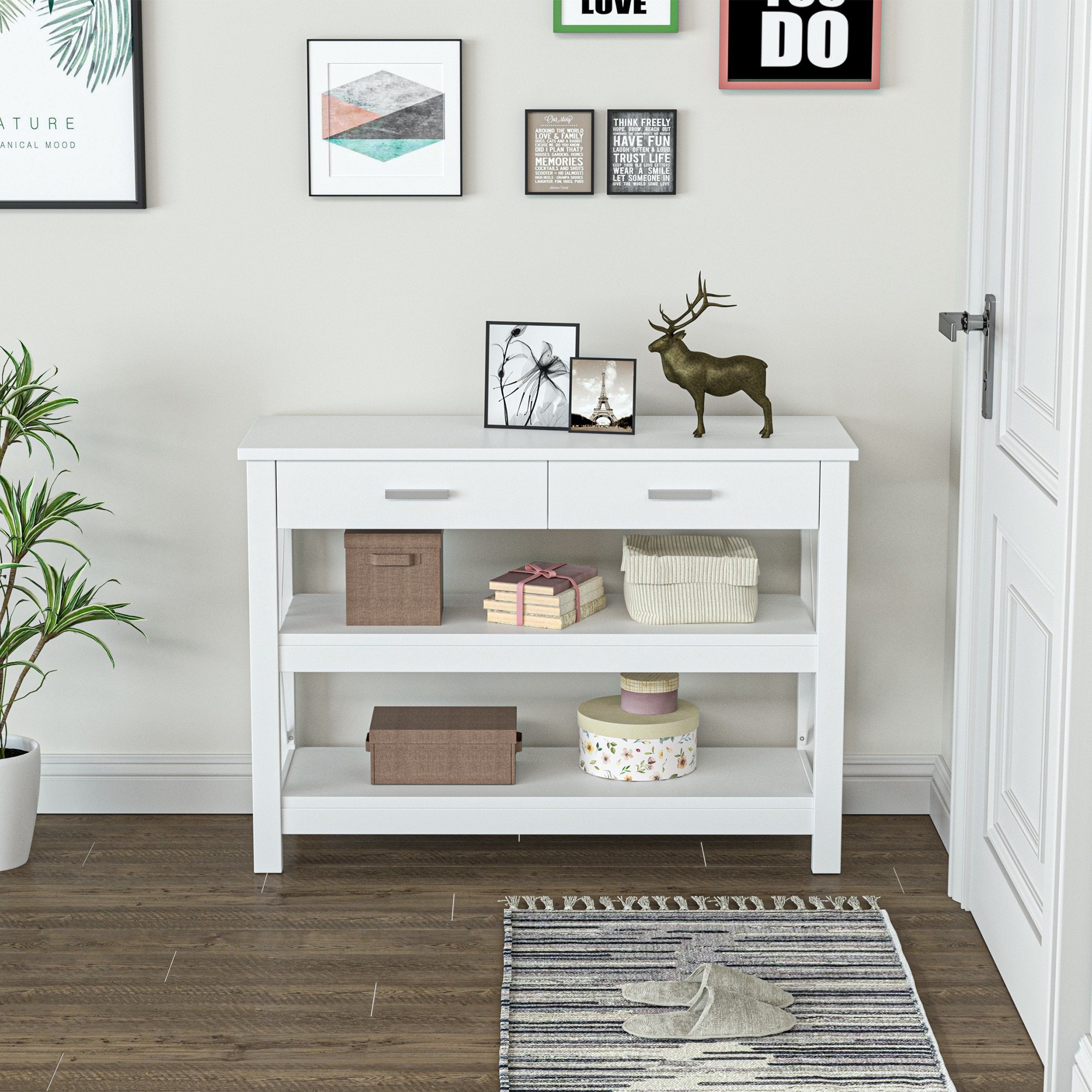 Consola blanca con decoración: planta, arte enmarcado, estatua de ciervo, cajas, libros, alfombra, zapatillas.