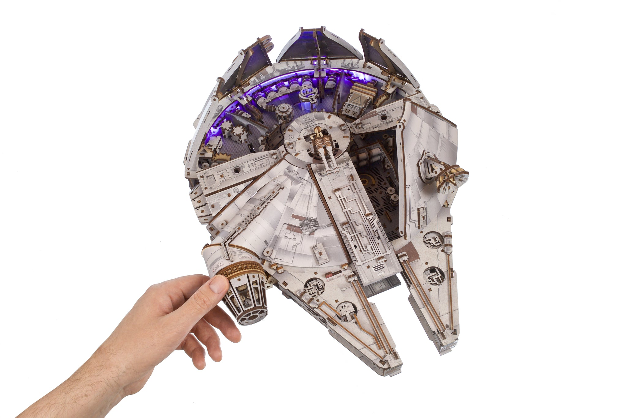 Ein Modell des Millennium Falken mit beleuchtetem Innenraum wird von einer Hand gehalten.