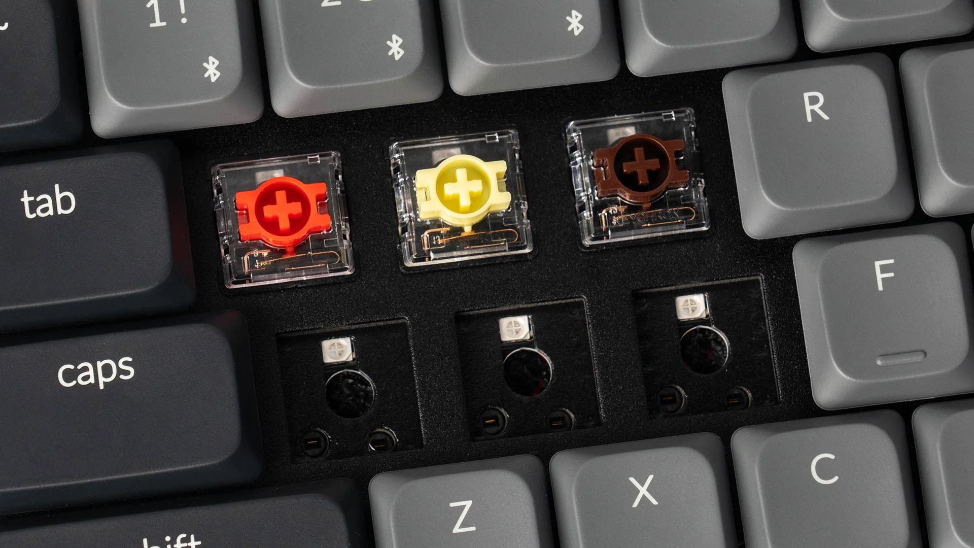 Trzy przełączniki klawiatury w kolorze czerwonym, żółtym i brązowym.