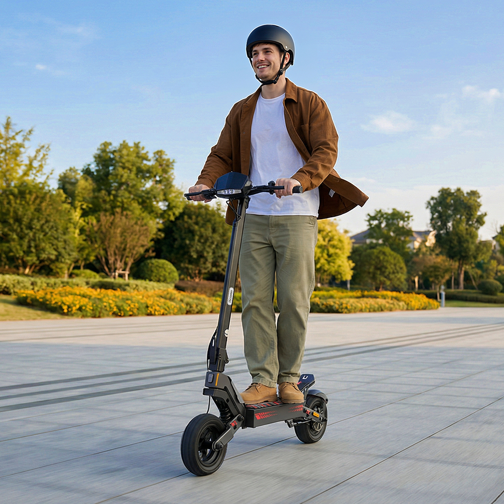 Uomo con casco guida monopattino elettrico in parco soleggiato.