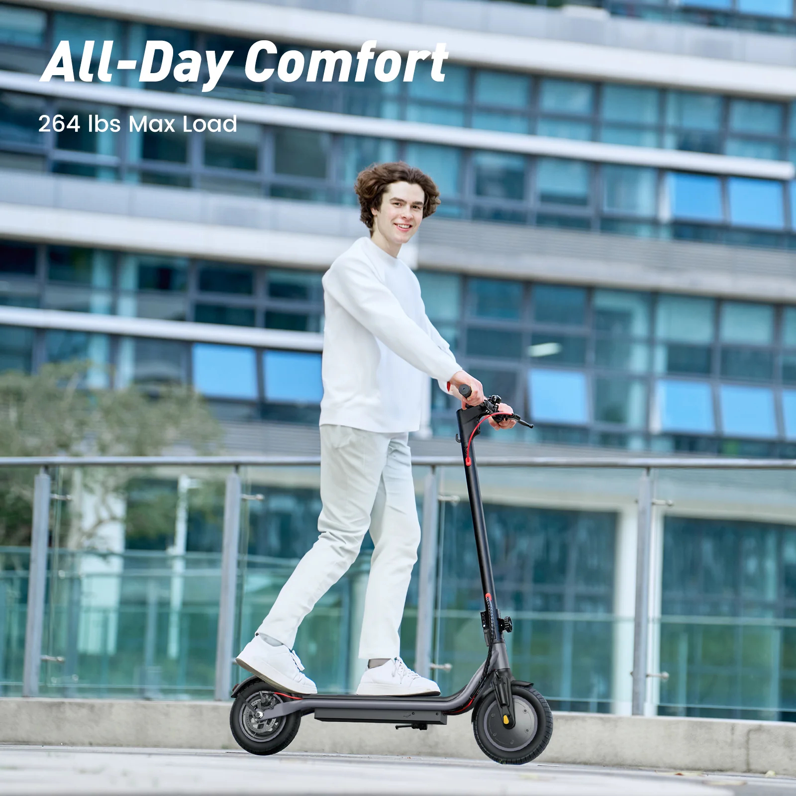 Un giovane guida uno scooter elettrico nero davanti a un edificio moderno.