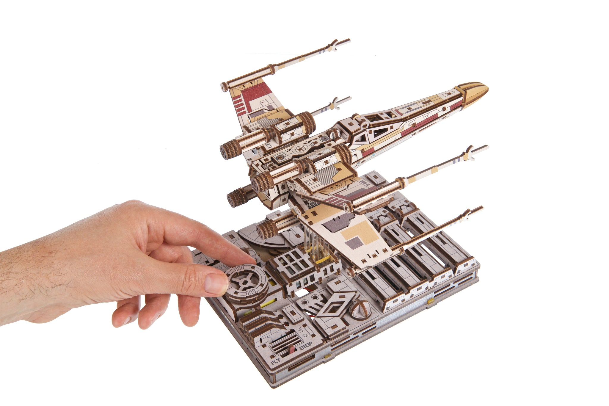 Ein Mensch berührt ein hölzernes X-Wing-Modell auf einem Diorama.