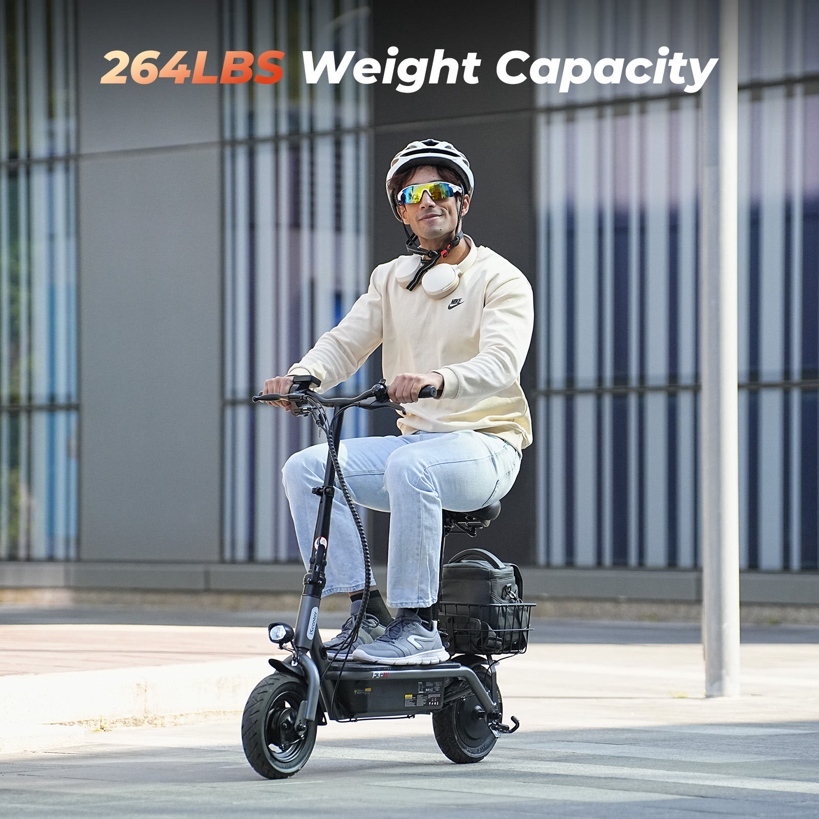 Un uomo guida uno scooter elettrico grigio, con casco e occhiali da sole.