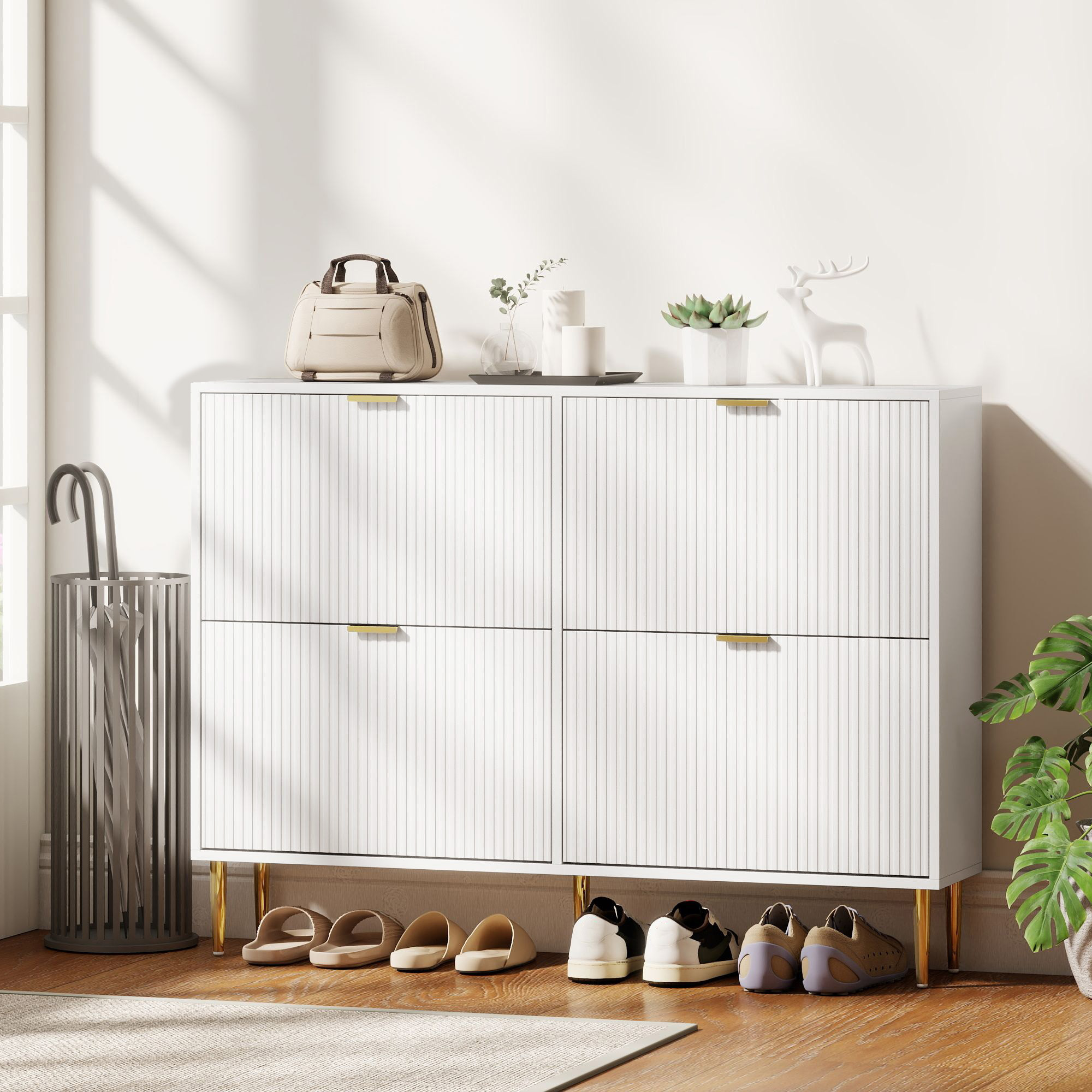 Un zapatero blanco de cuatro puertas, decorado con bolso, velas, planta y ciervo.