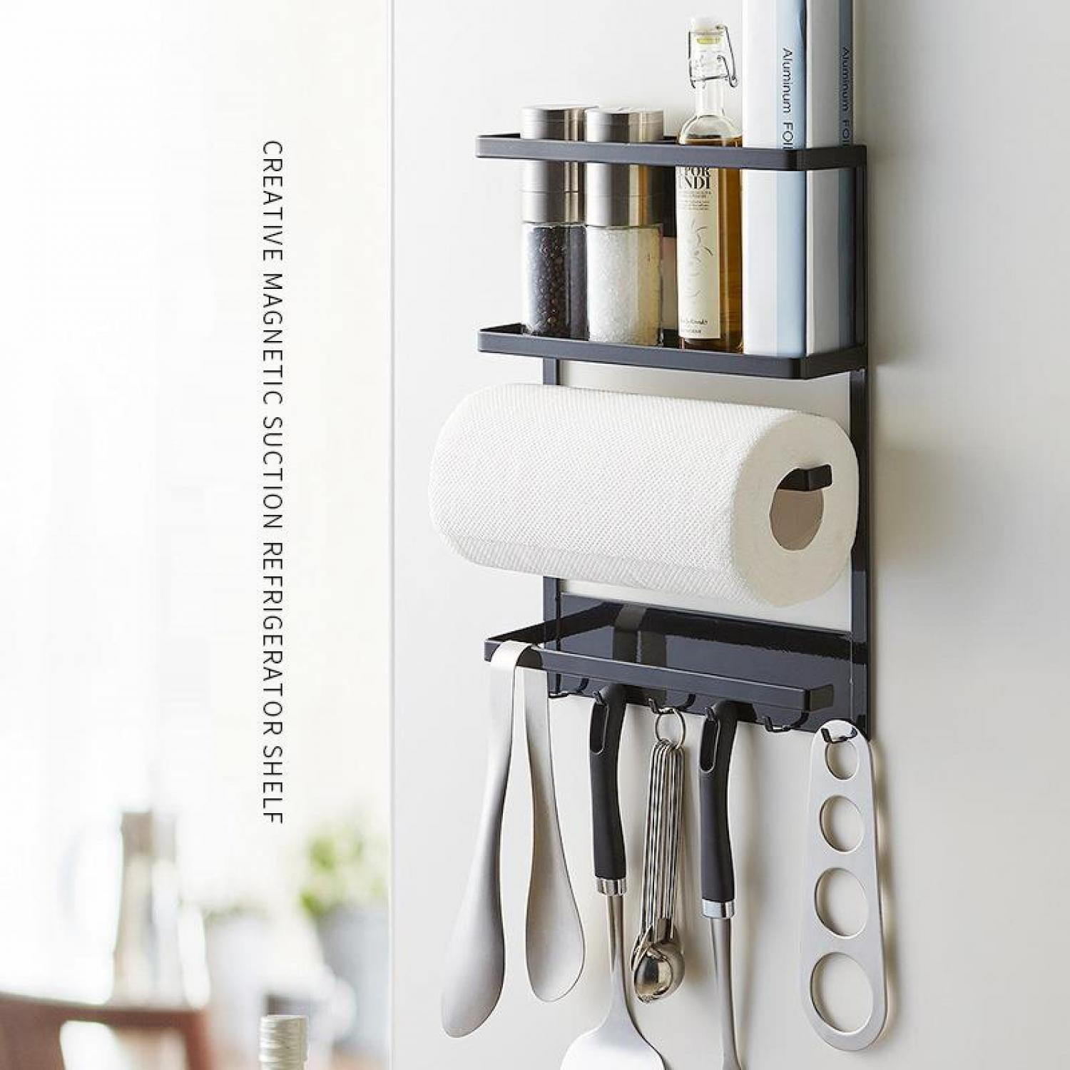 Ein schwarzes Magnetregal hält Gewürze, Küchenpapier und Utensilien an einer weißen Wand.