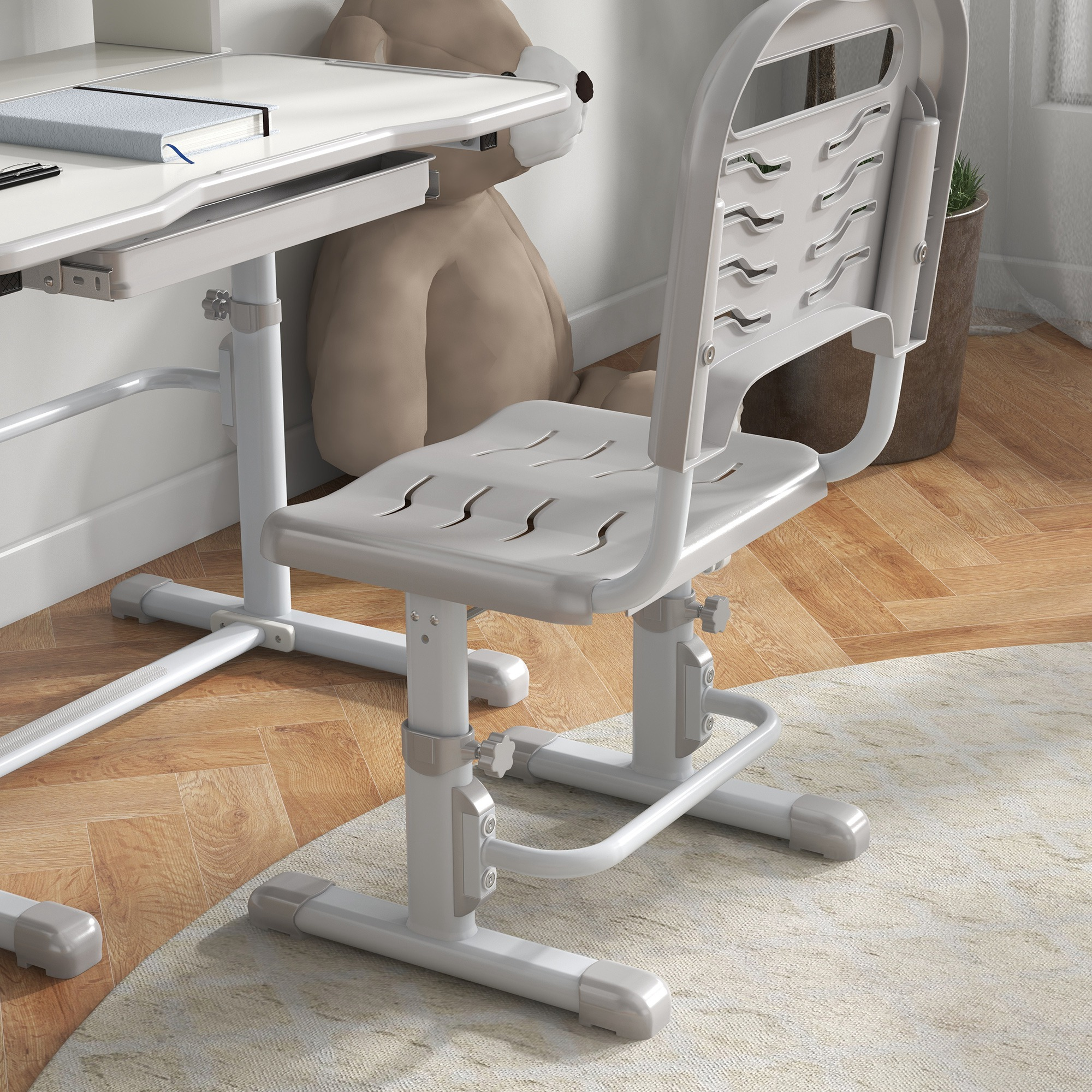 Una silla de escritorio blanca de altura ajustable frente a un oso de peluche marrón.