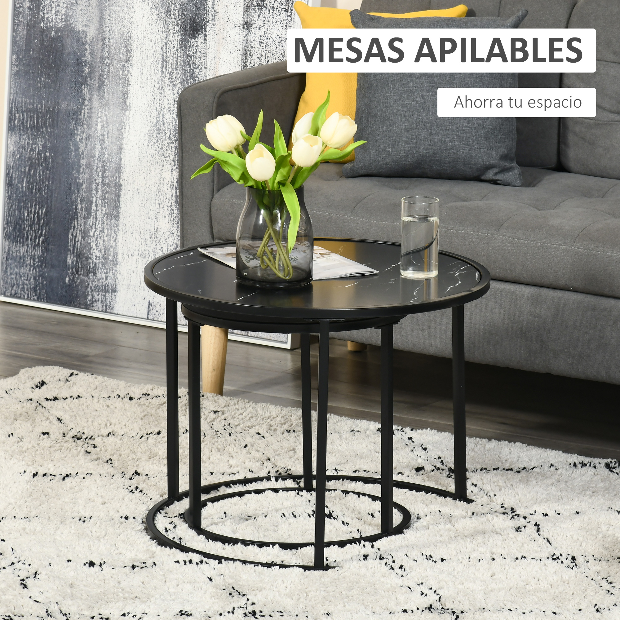 Dos mesas nido de mármol negro sobre una alfombra mullida. Tulipanes blancos en un jarrón.