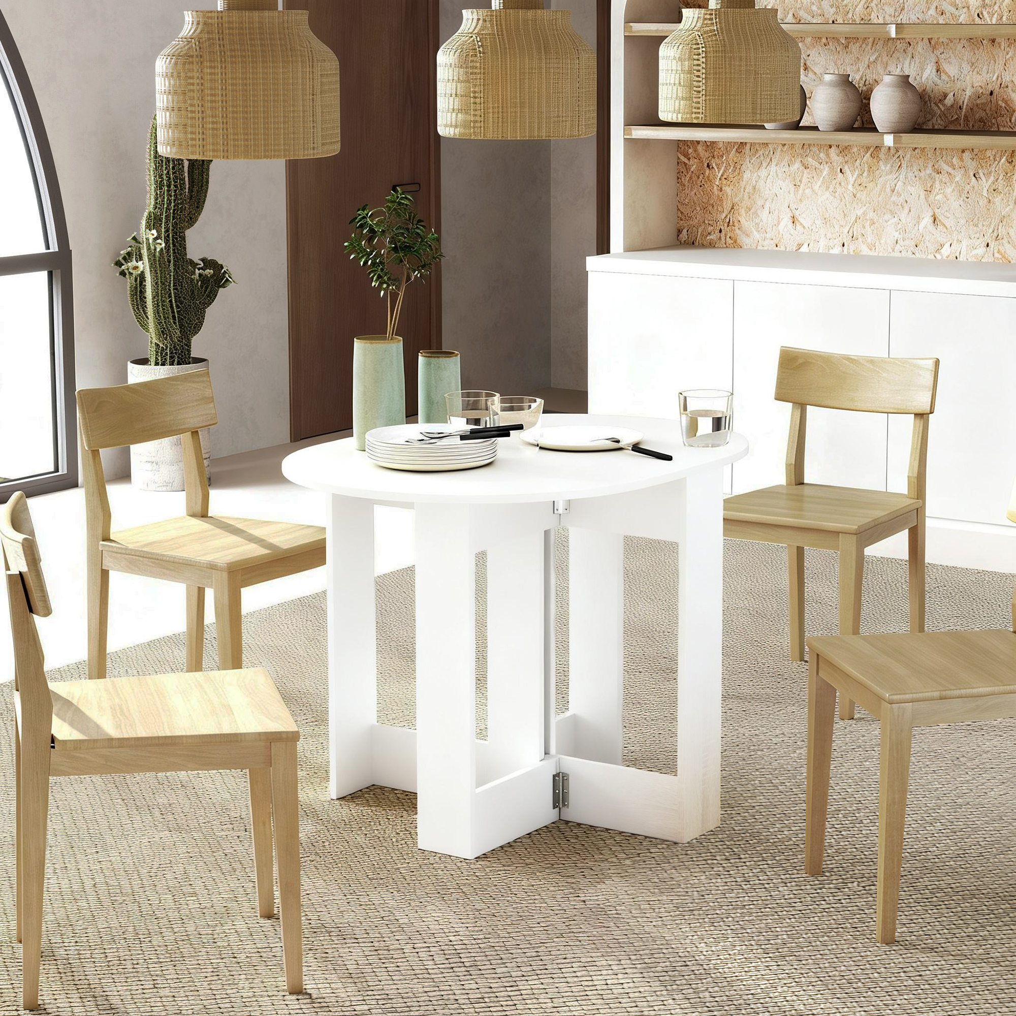 Una mesa redonda blanca con cuatro sillas de madera en una habitación luminosa con cactus y jarrones.