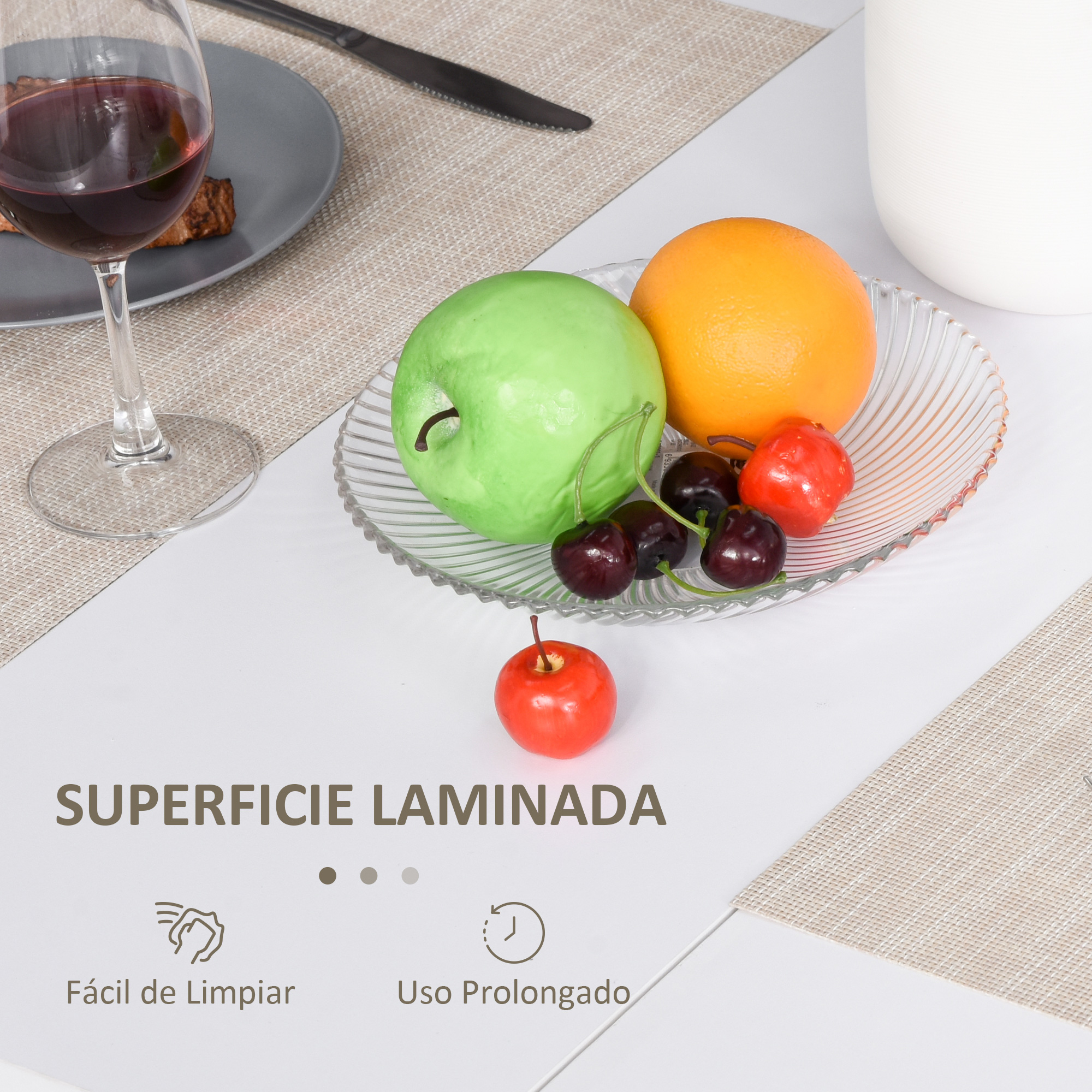 Una manzana verde, una naranja y cerezas en un plato de cristal sobre una mesa.