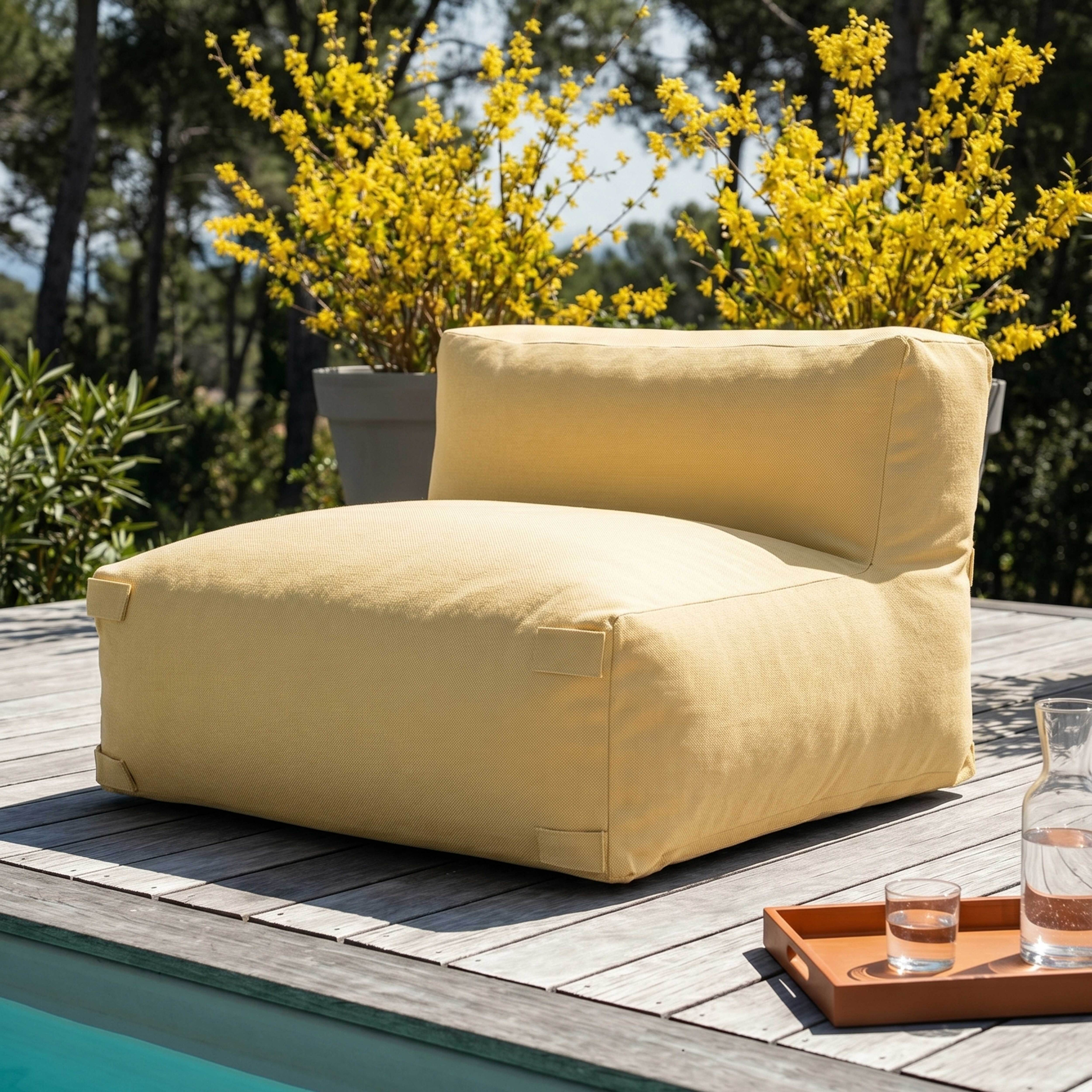 Ein gelber Sessel steht auf einer Holzterrasse neben einem Pool.