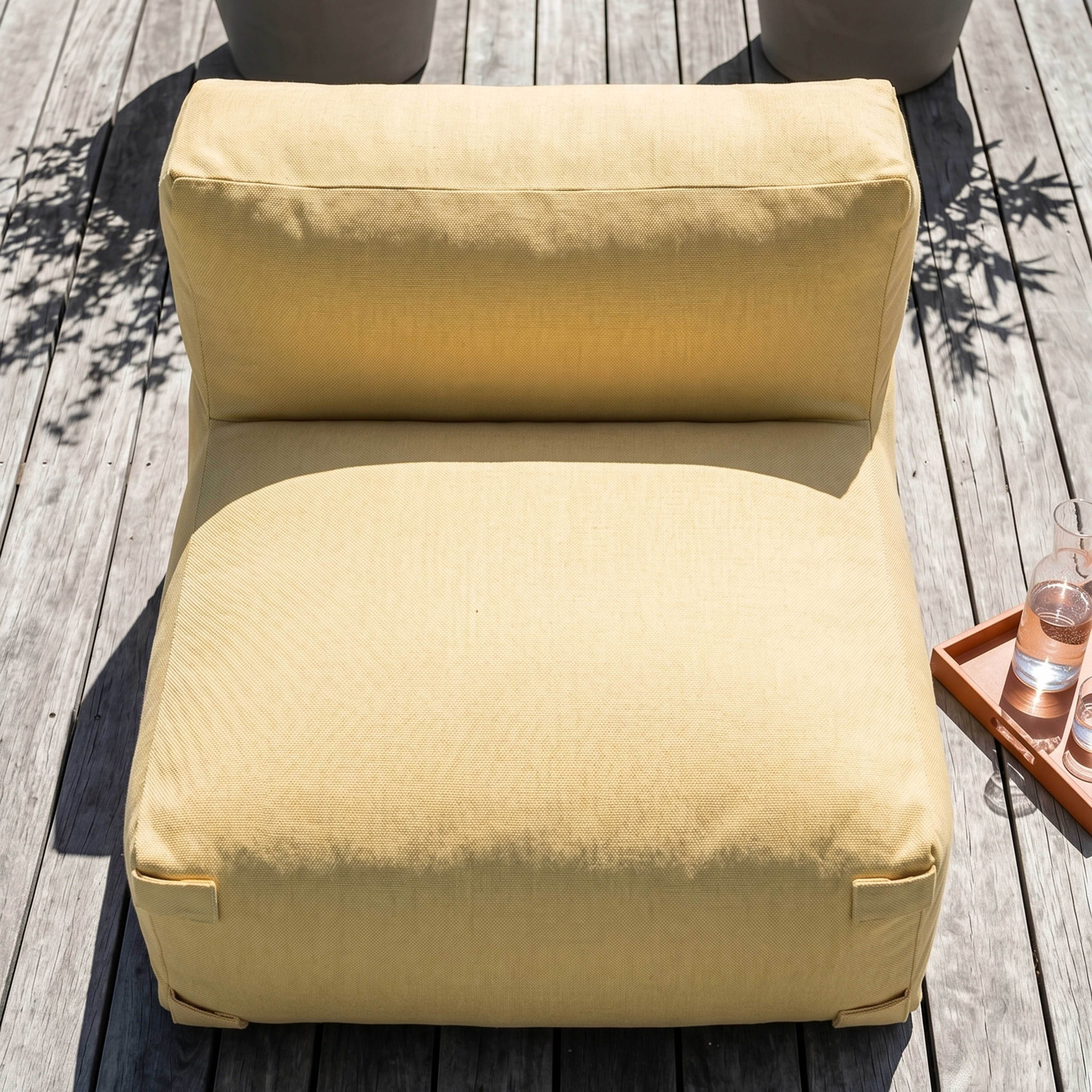 Ein gelber Sessel steht auf einer Holzterrasse im Freien.
