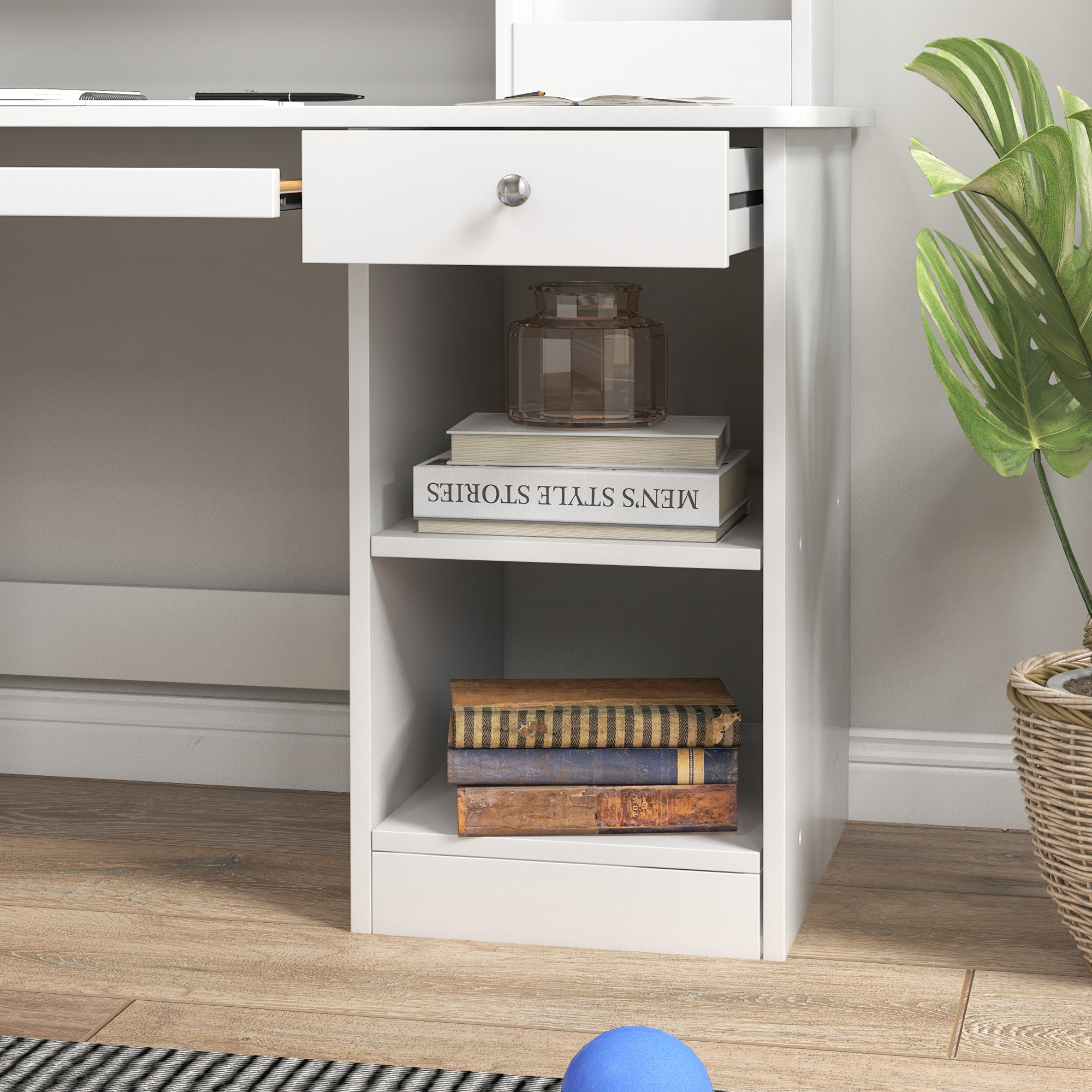 Un escritorio blanco con cajones, libros y un jarrón.