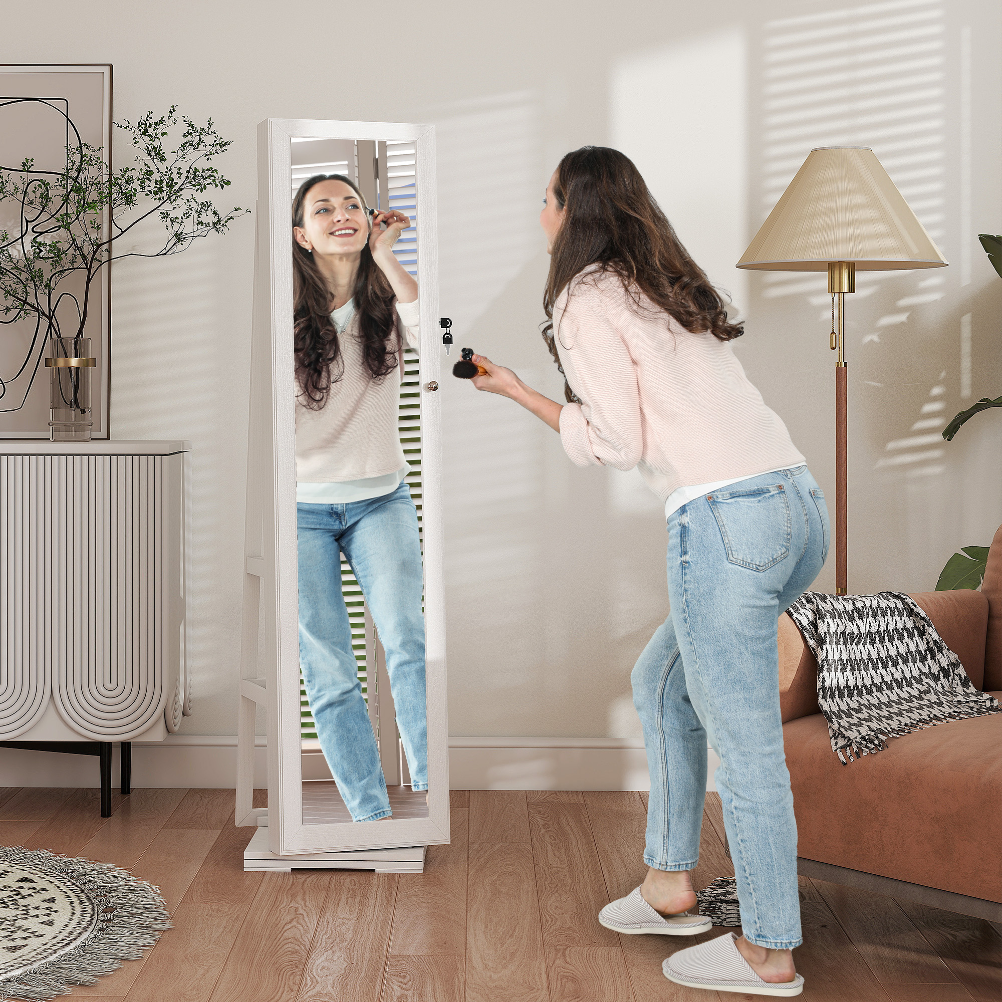 Una mujer se maquilla frente a un espejo en una habitación elegante con muebles y lámpara.
