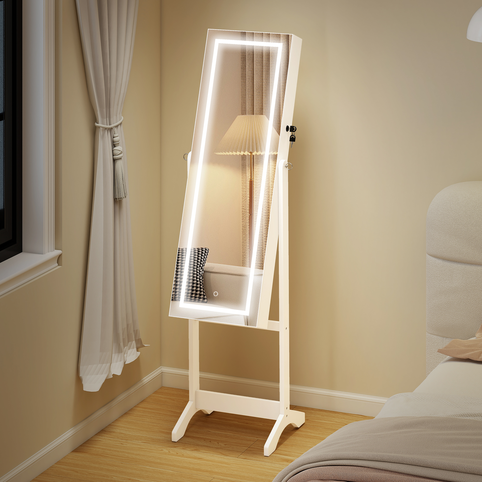 Un armadio portagioie bianco con specchio illuminato si trova su un pavimento in legno vicino a un letto.
