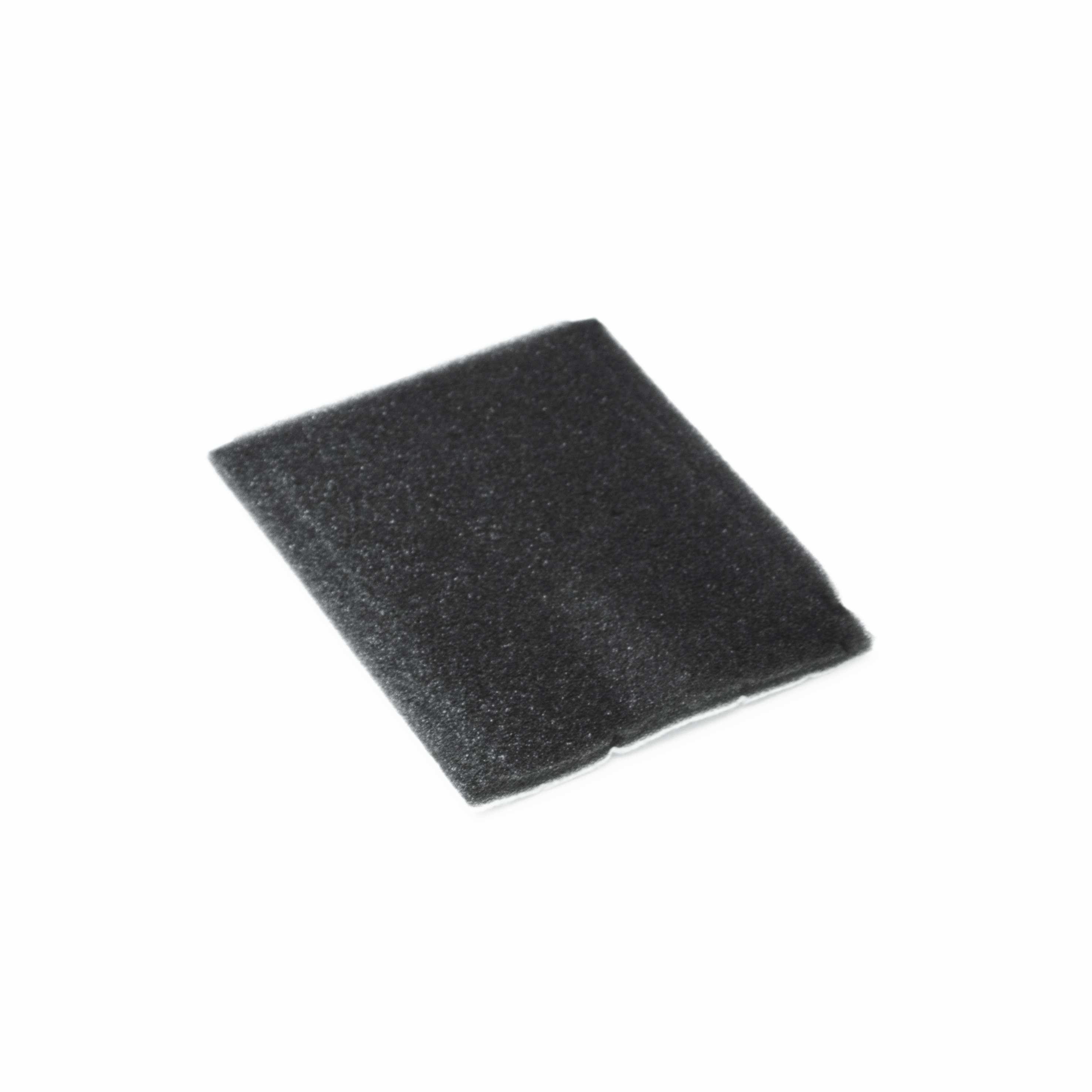Een klein zwart schuimrubber stuk ligt geïsoleerd op een witte achtergrond.