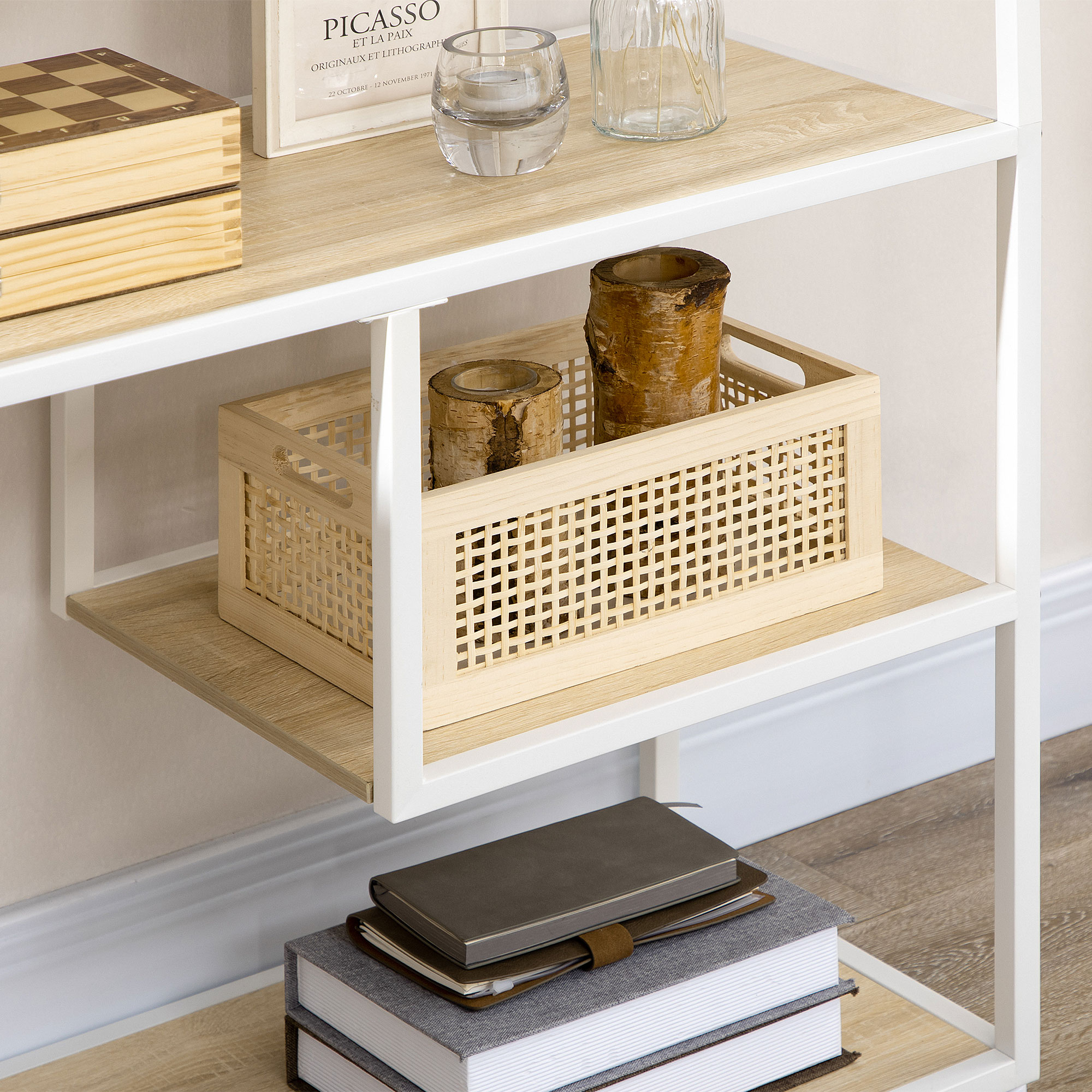 Una estantería de madera clara muestra un juego de ajedrez, troncos en una cesta tejida y libros.