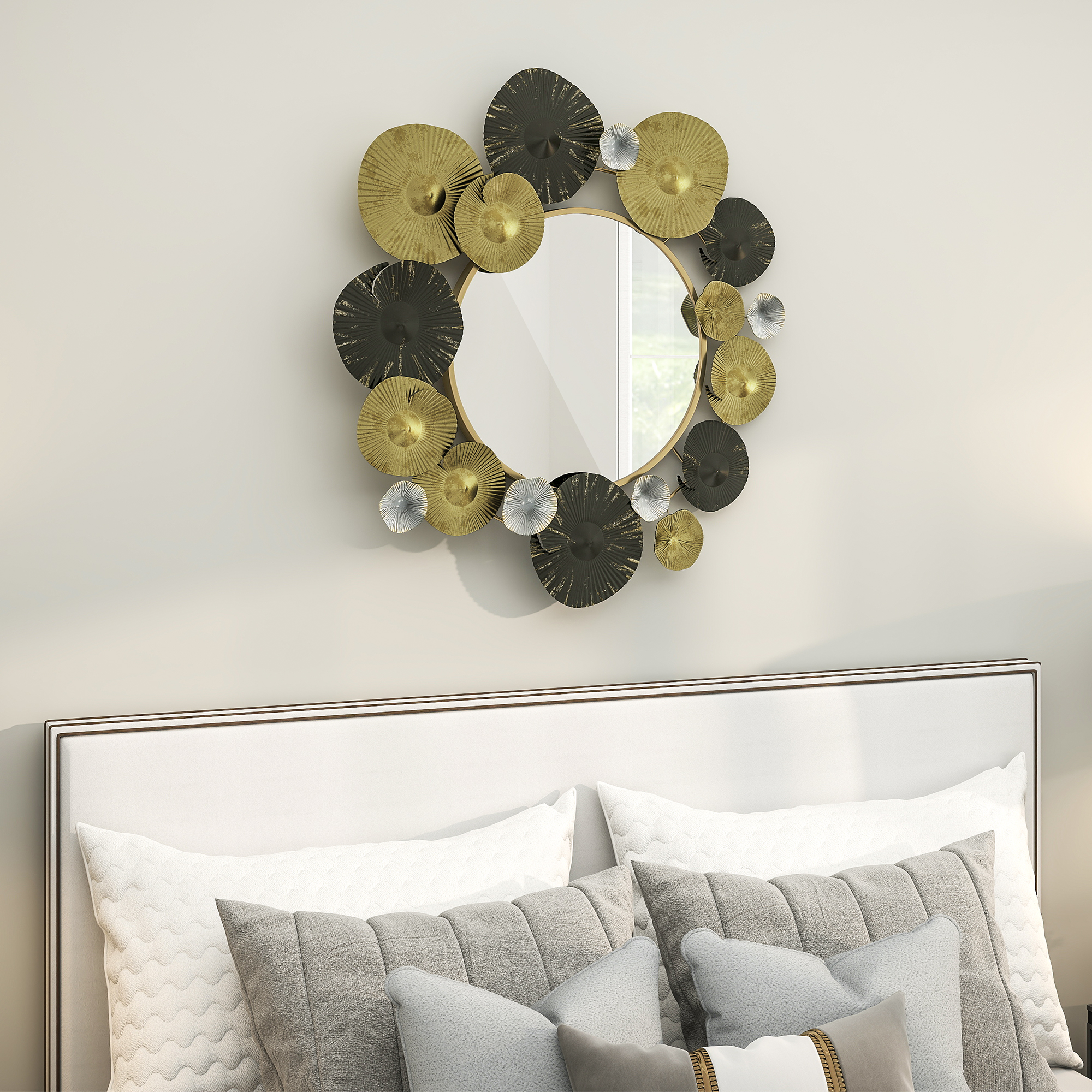 Espejo redondo con pétalos metálicos dorados y negros decorativos de pared sobre una cama blanca.