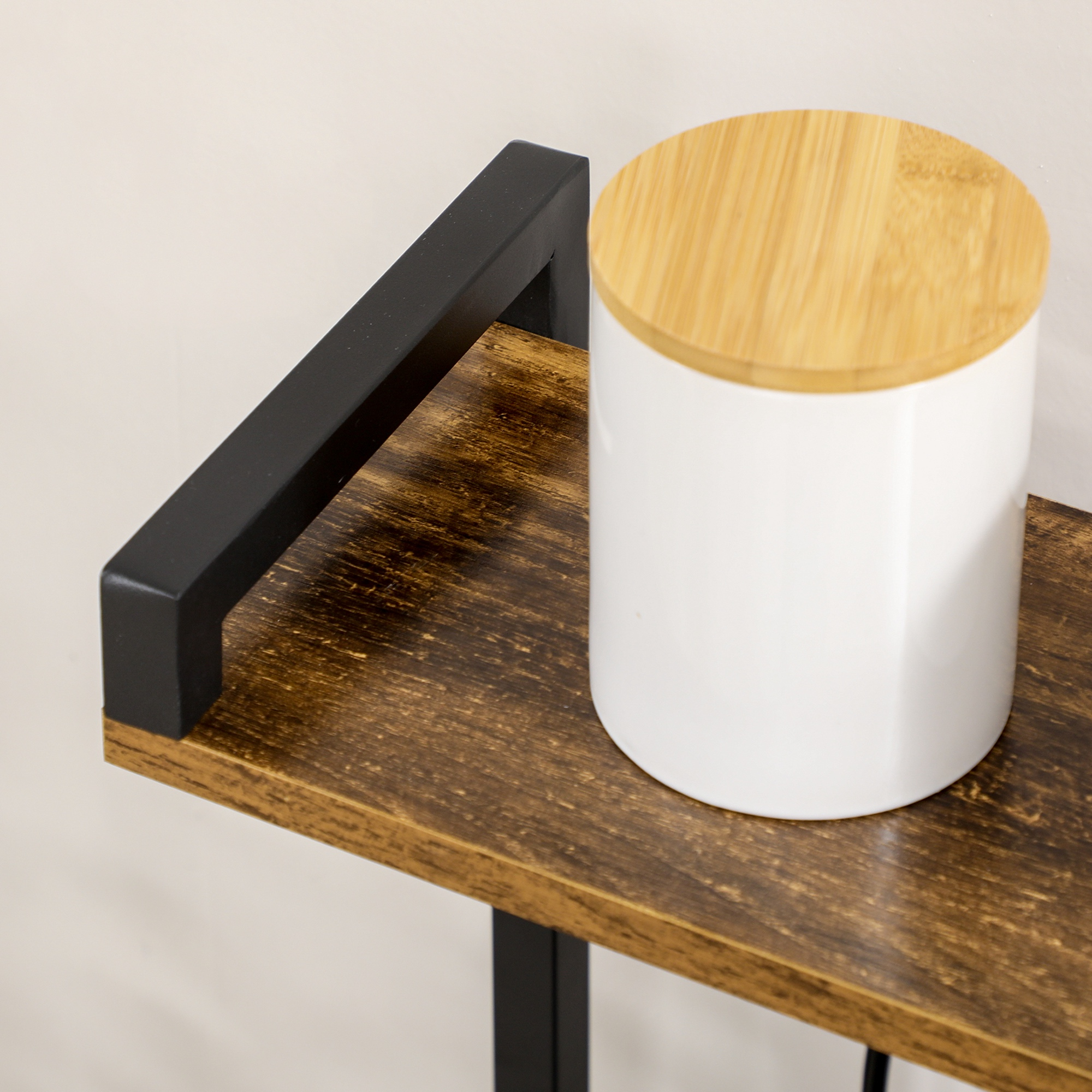 Un recipiente blanco con tapa de madera descansa sobre un estante rústico de madera.