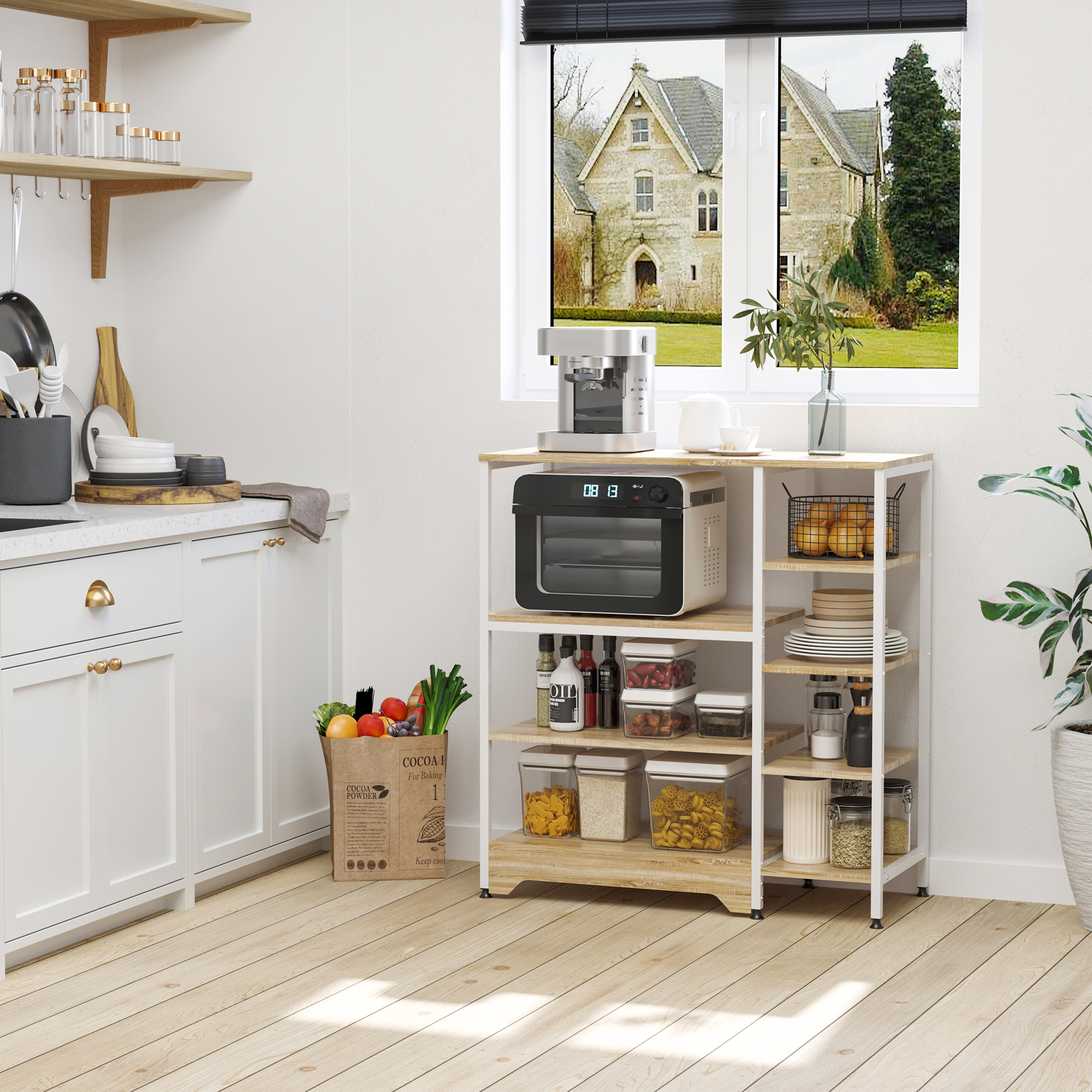 Cocina moderna con isla, electrodomésticos, comestibles y vista a una casa.