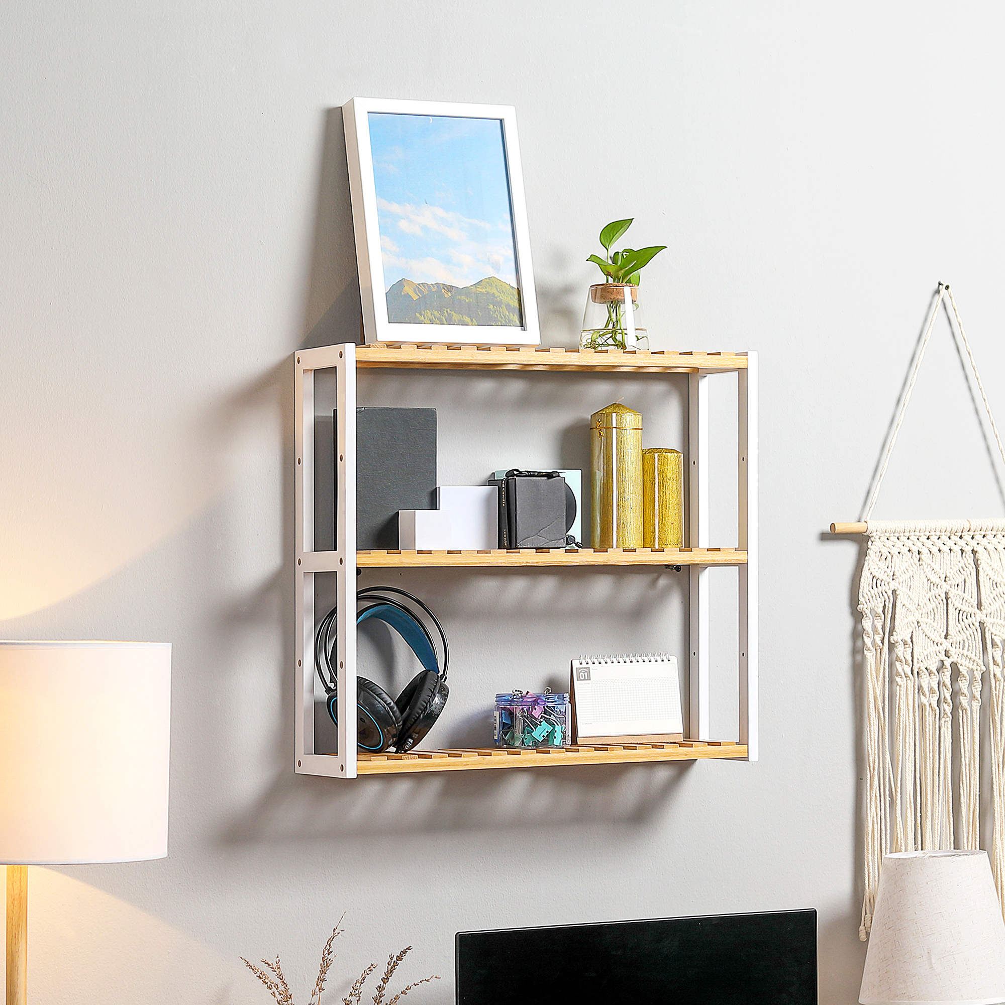 Un estante muestra libros, auriculares, velas y un calendario.