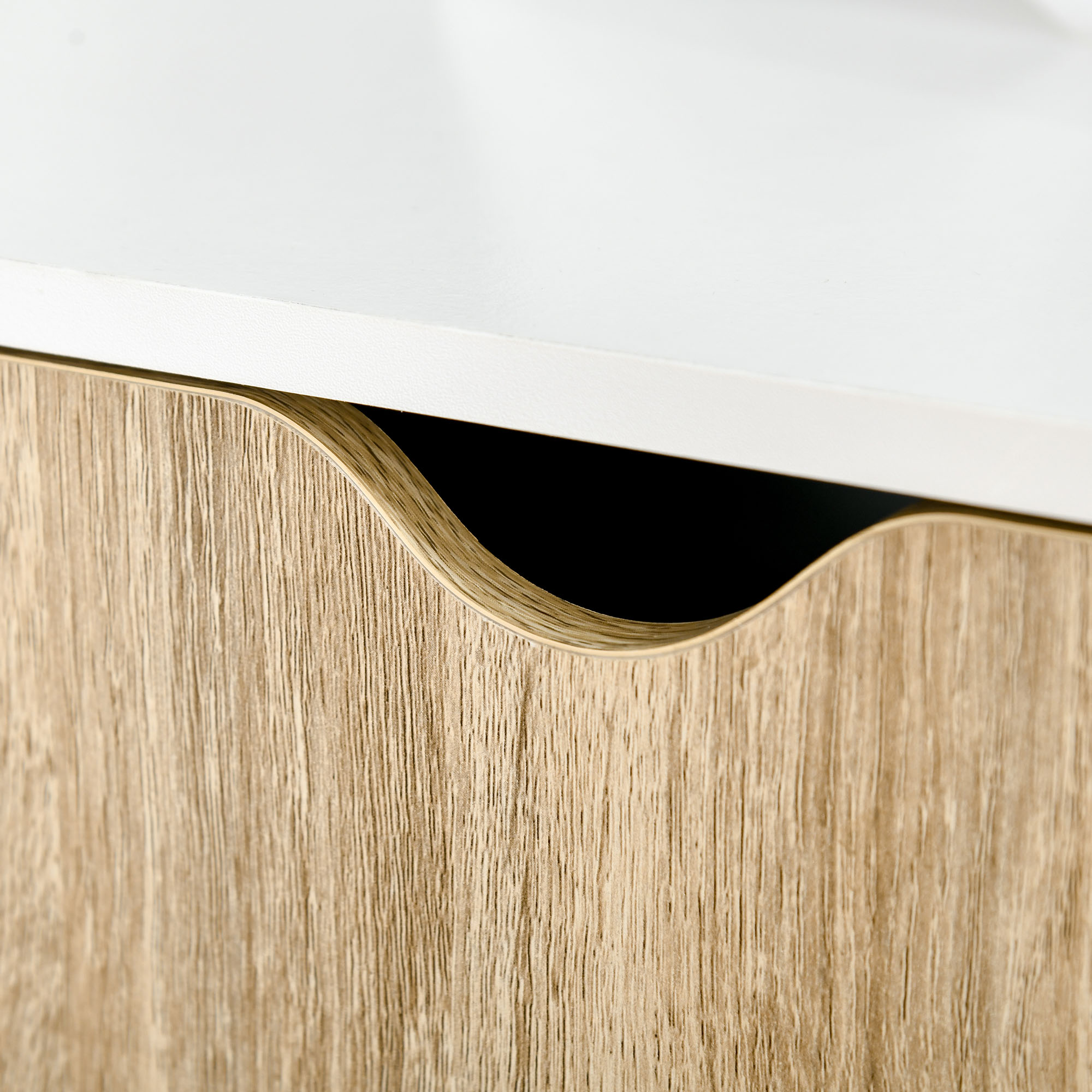 Primer plano de un cajón con veta de madera y superficie superior blanca.
