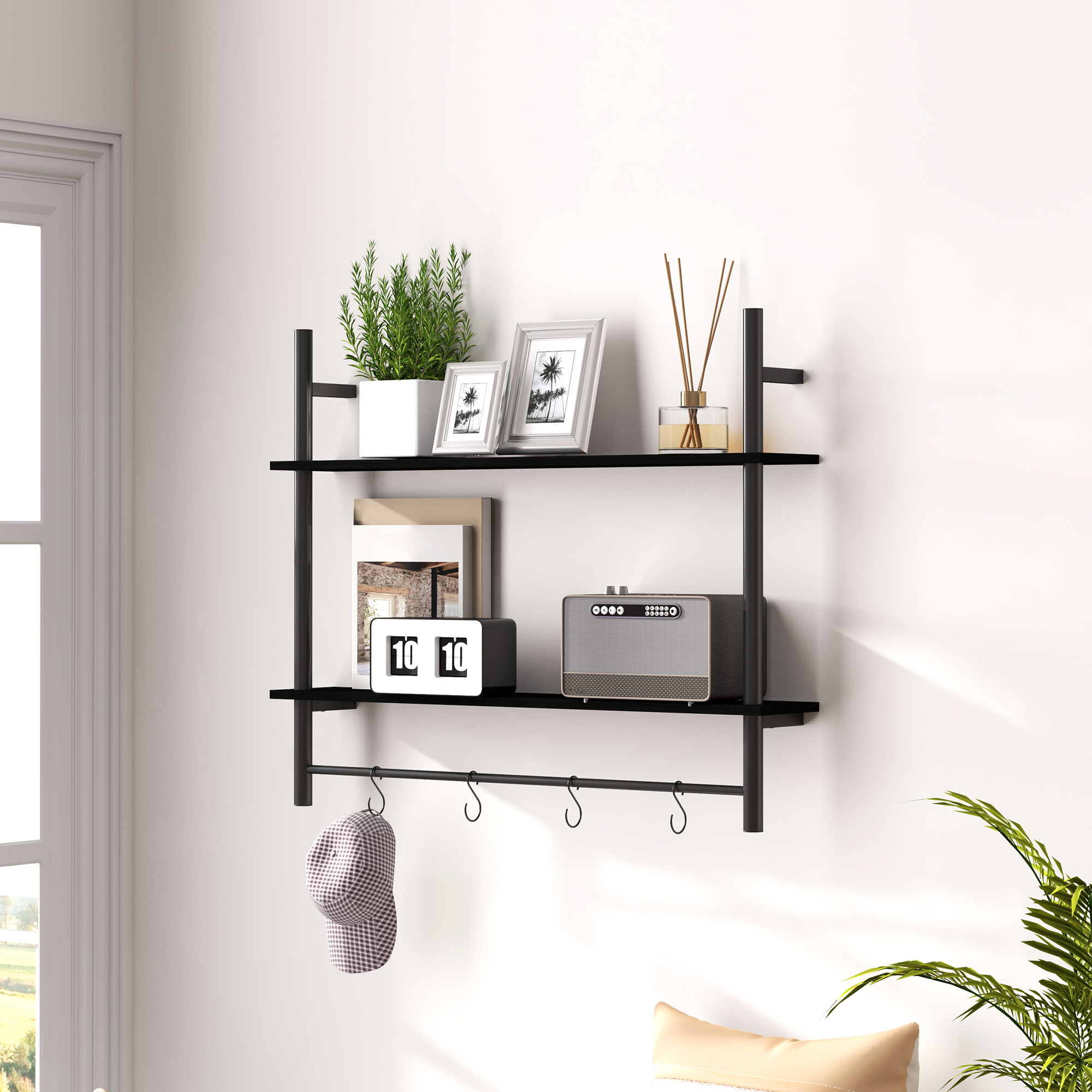 Un estante negro de pared muestra decoraciones: planta, fotos, difusor, reloj y altavoz. Un sombrero cuelga abajo.