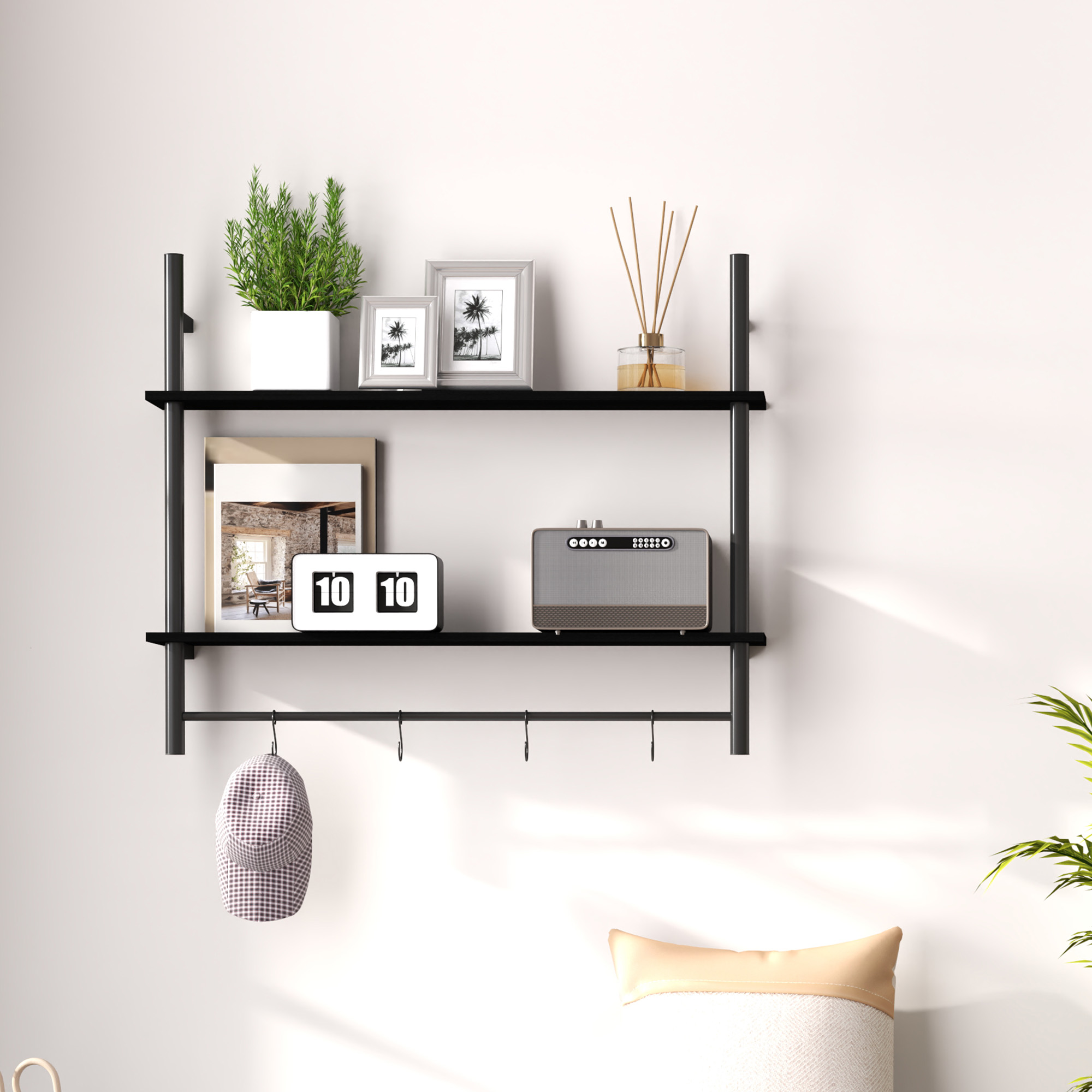 Un estante negro con decoraciones: planta, cuadros, altavoz, reloj y gorra.