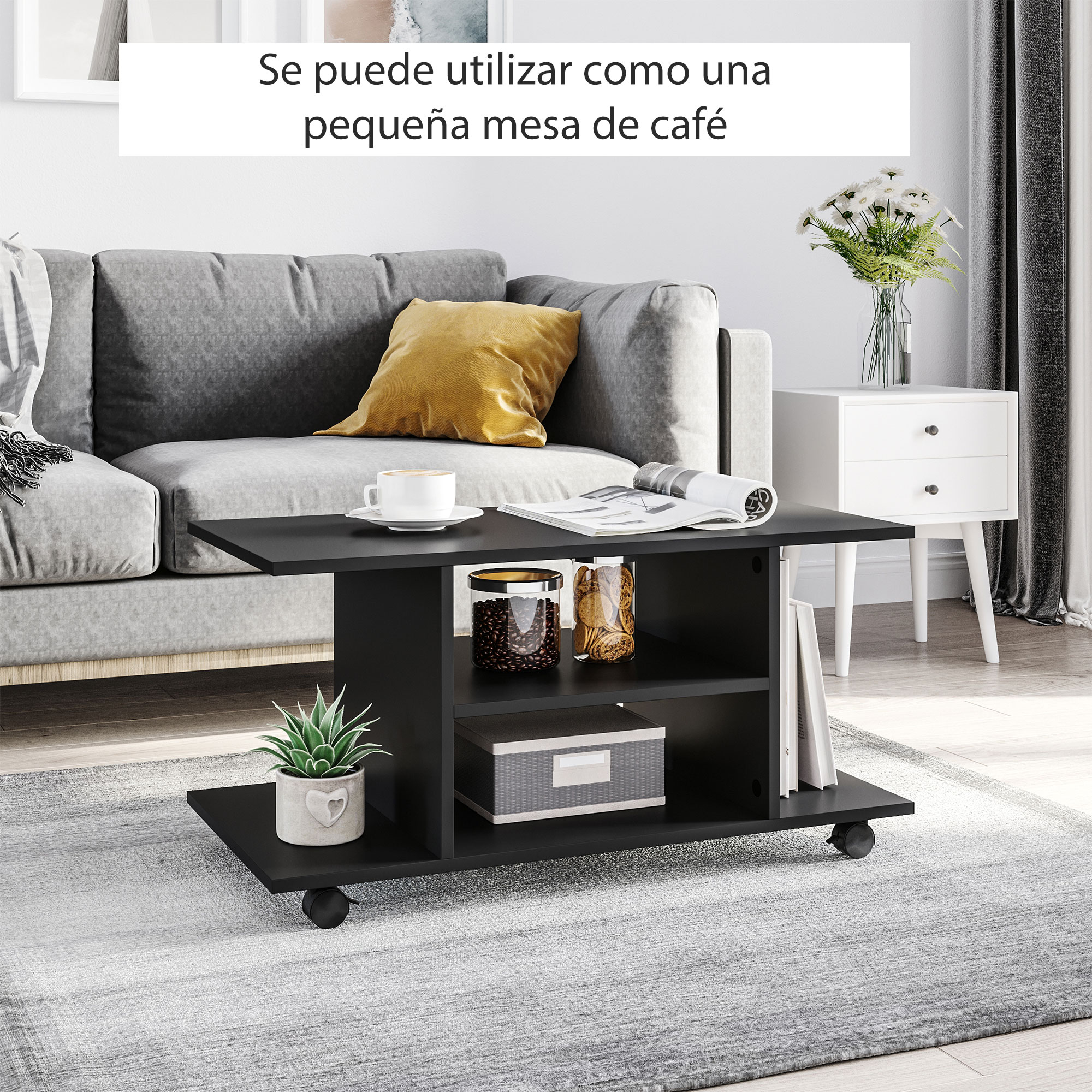 Una mesa de centro negra con libros, frascos y una planta se sienta sobre una alfombra frente a un sofá gris.