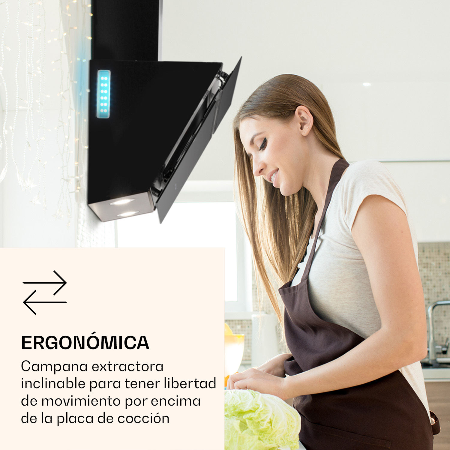 Una mujer cocina en una cocina bajo una campana extractora negra.