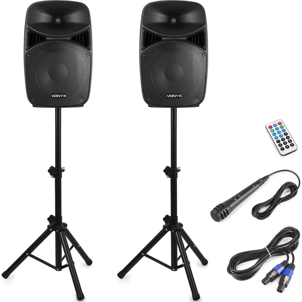 Dos altavoces VONYX negros en soportes con micrófono, control remoto y cables.