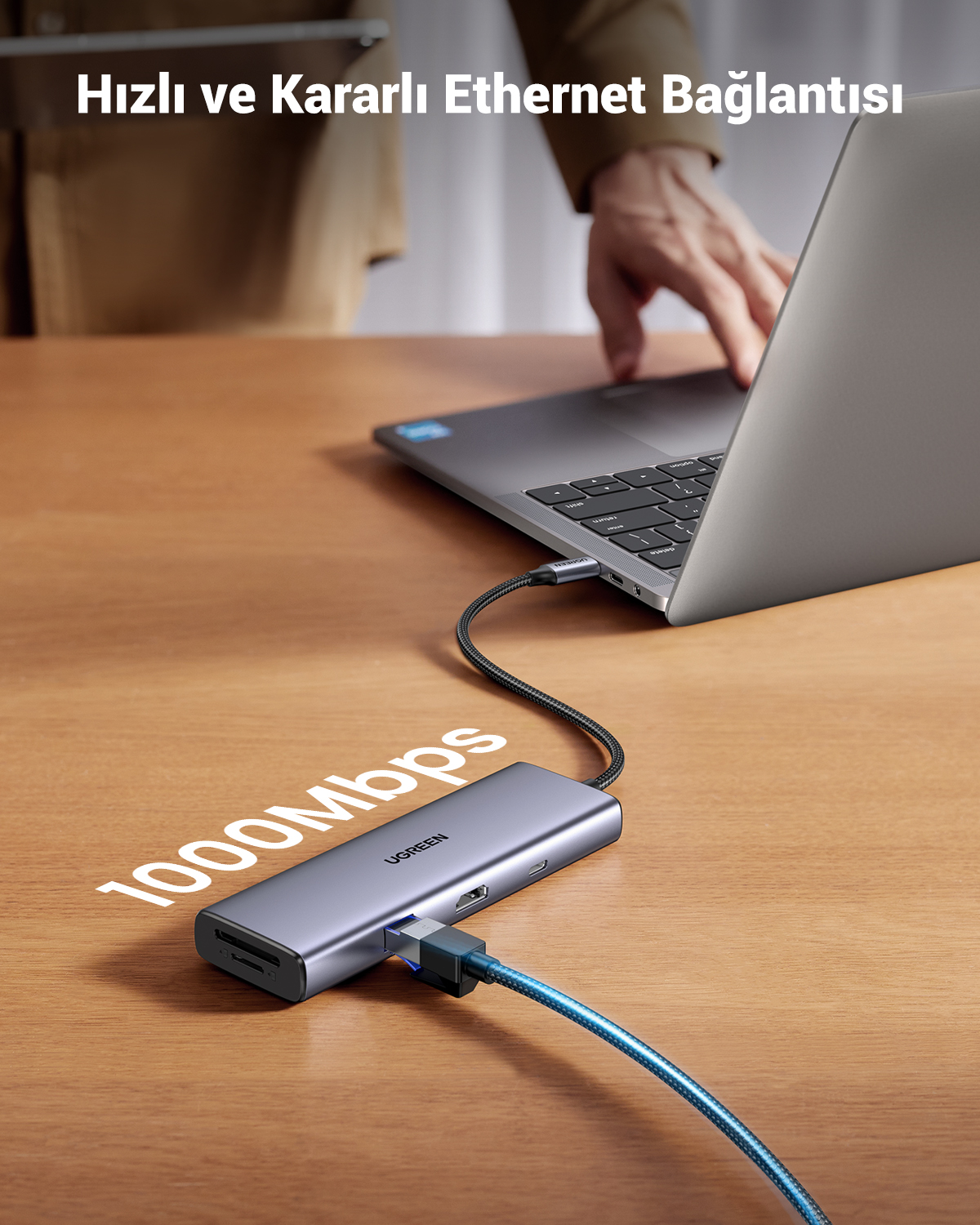 Szary hub USB-C z czytnikiem kart SD podłączony do laptopa. 1000Mbps.