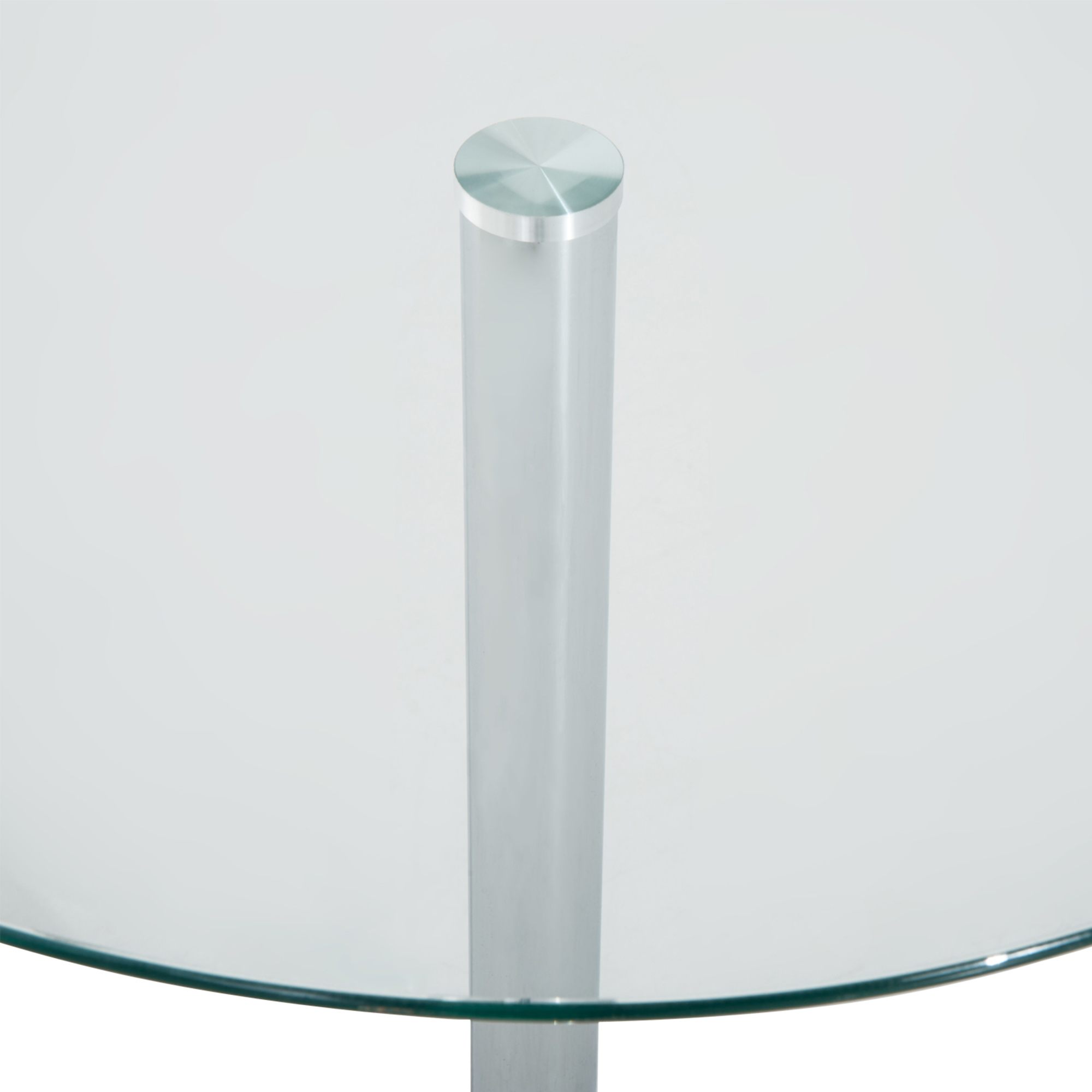 Primer plano de una mesa de cristal redonda con pata de metal pulido.