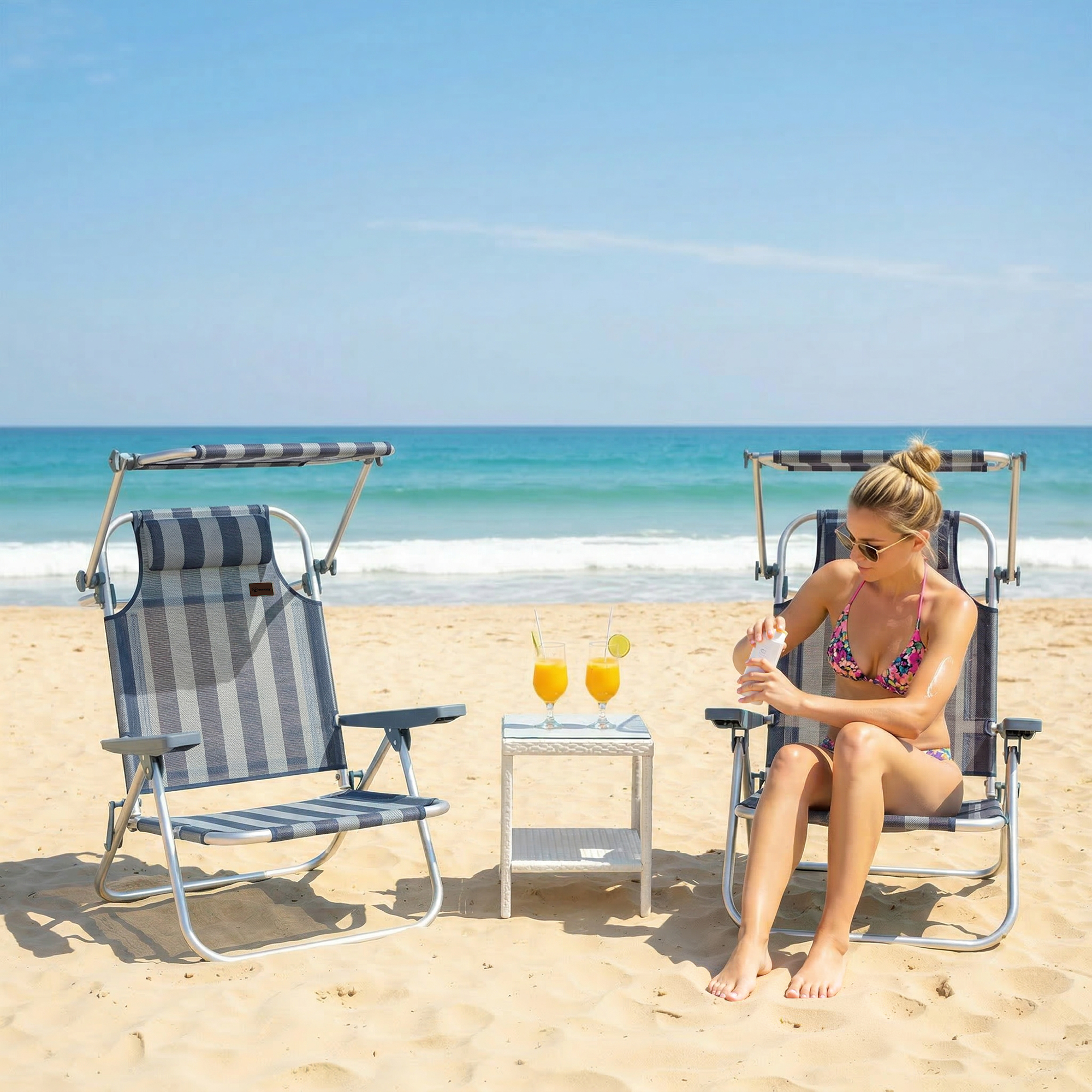 Mujer se aplica protector solar sentada en una silla de playa. Dos bebidas en una mesita.