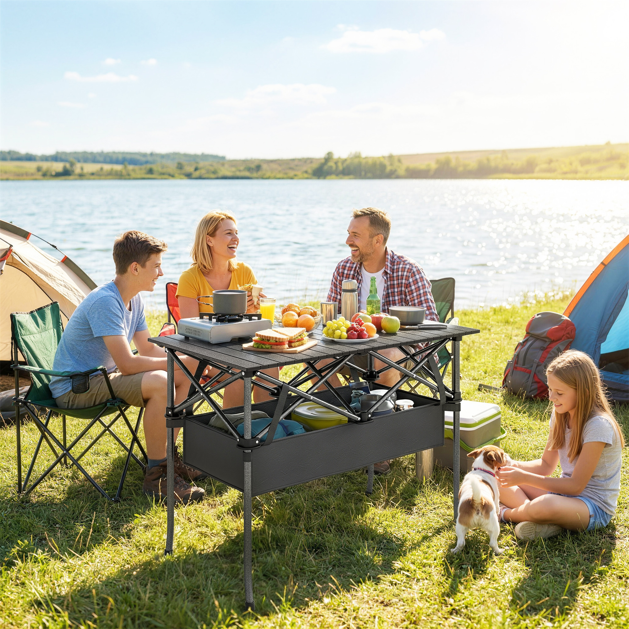 Familia acampando junto a un lago con comida y perro.