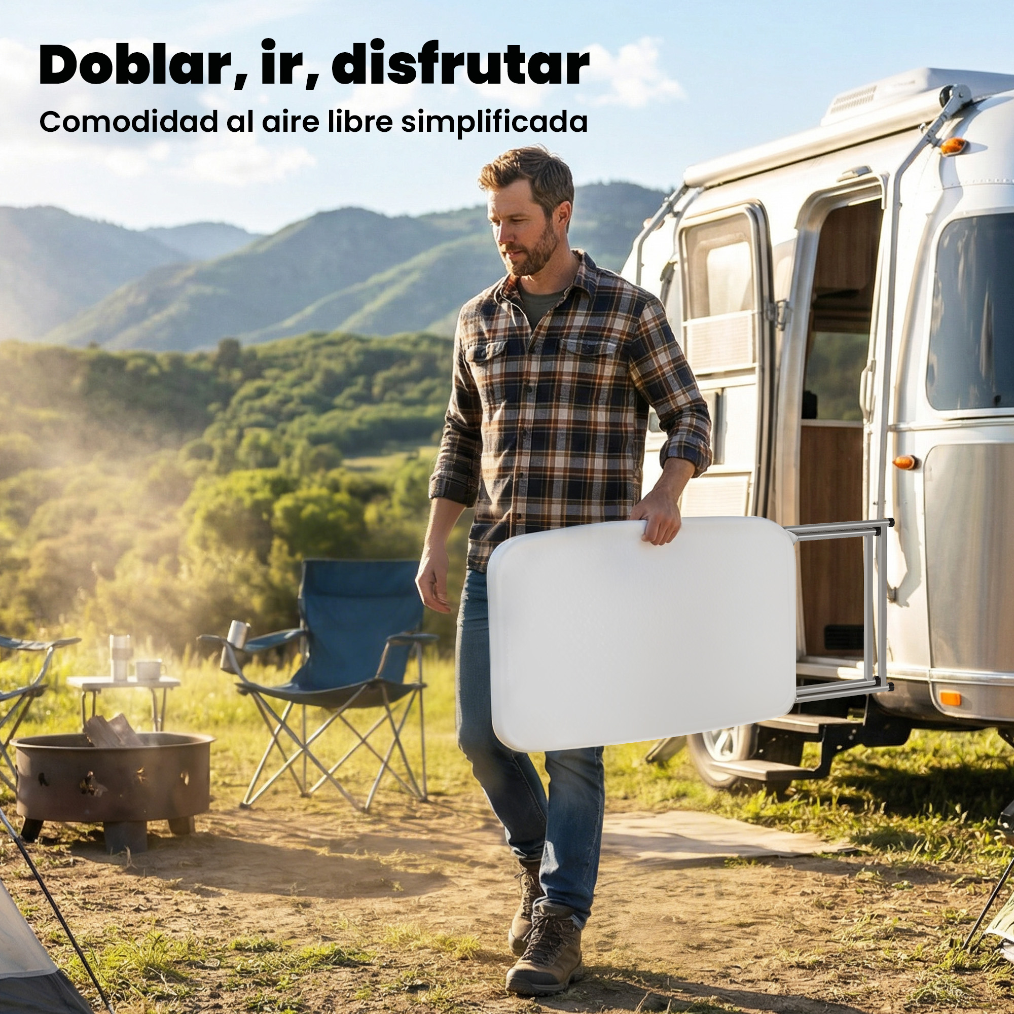 Hombre lleva mesa blanca cerca de autocaravana, camping con sillas y fogata al fondo.