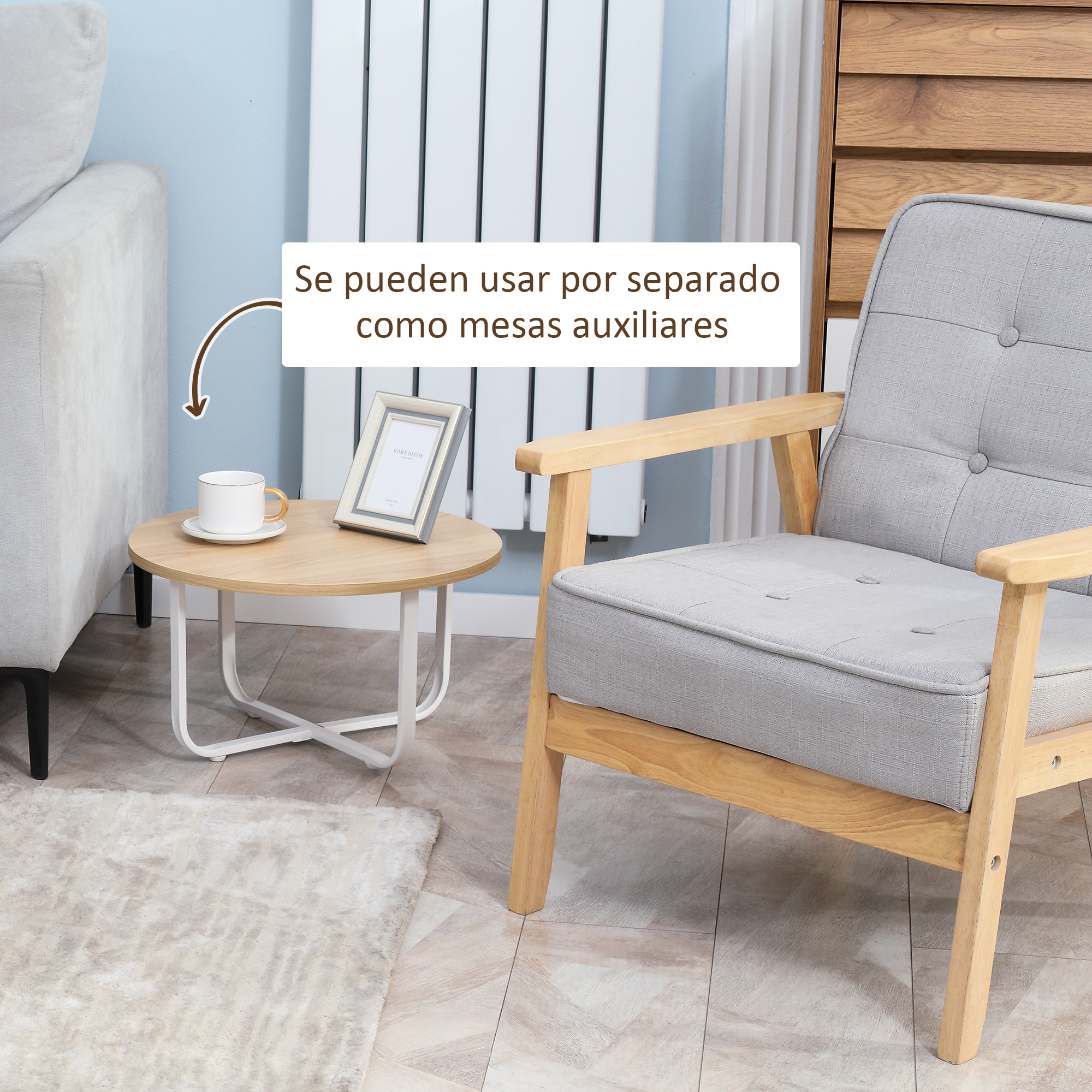 Una pequeña mesa de madera con taza y marco de fotos junto a un sillón gris.