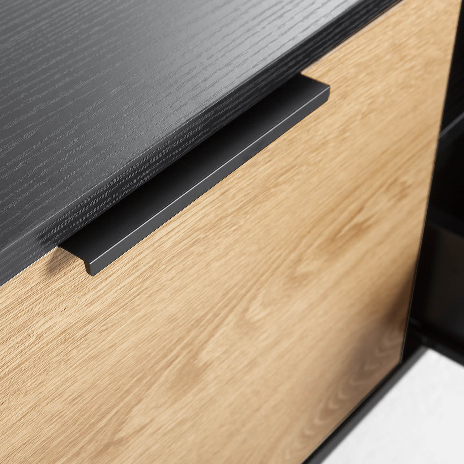 Primer plano de veta de madera con tirador y borde negros.