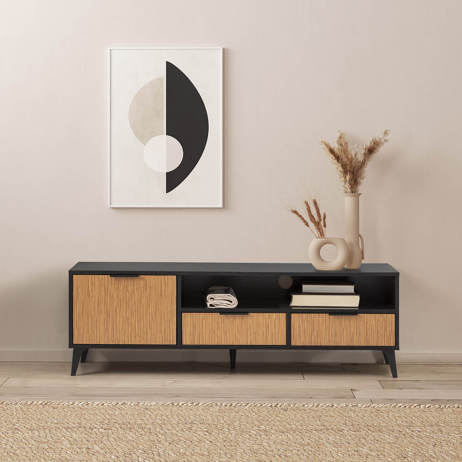 Un mueble de TV negro con detalles de madera, arte y flores secas.